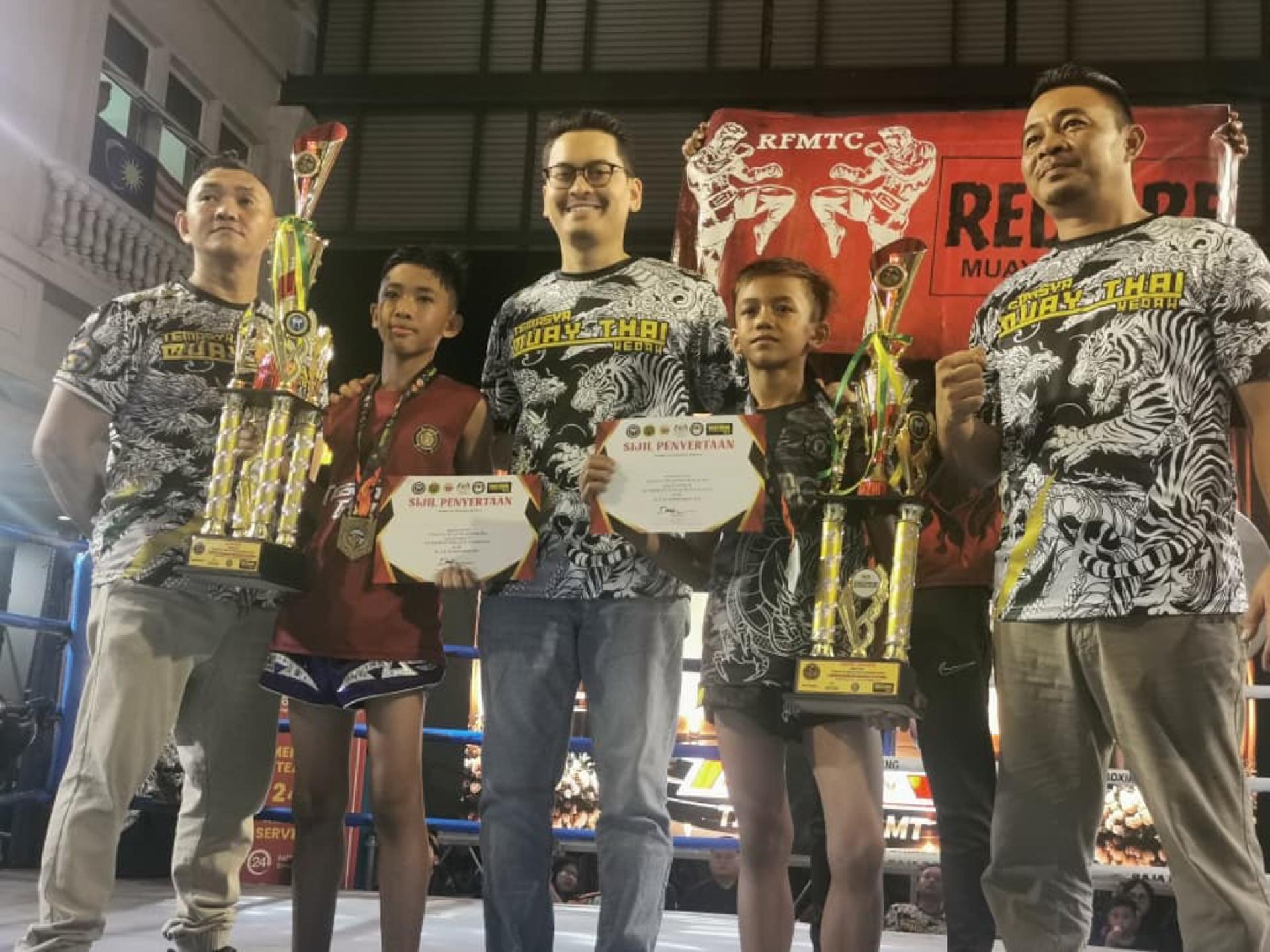 道菲（中）颁发奖品给12岁以下的冠军与亚军奖得主后合影，由许文隆（左）及再努汀（右）陪同。