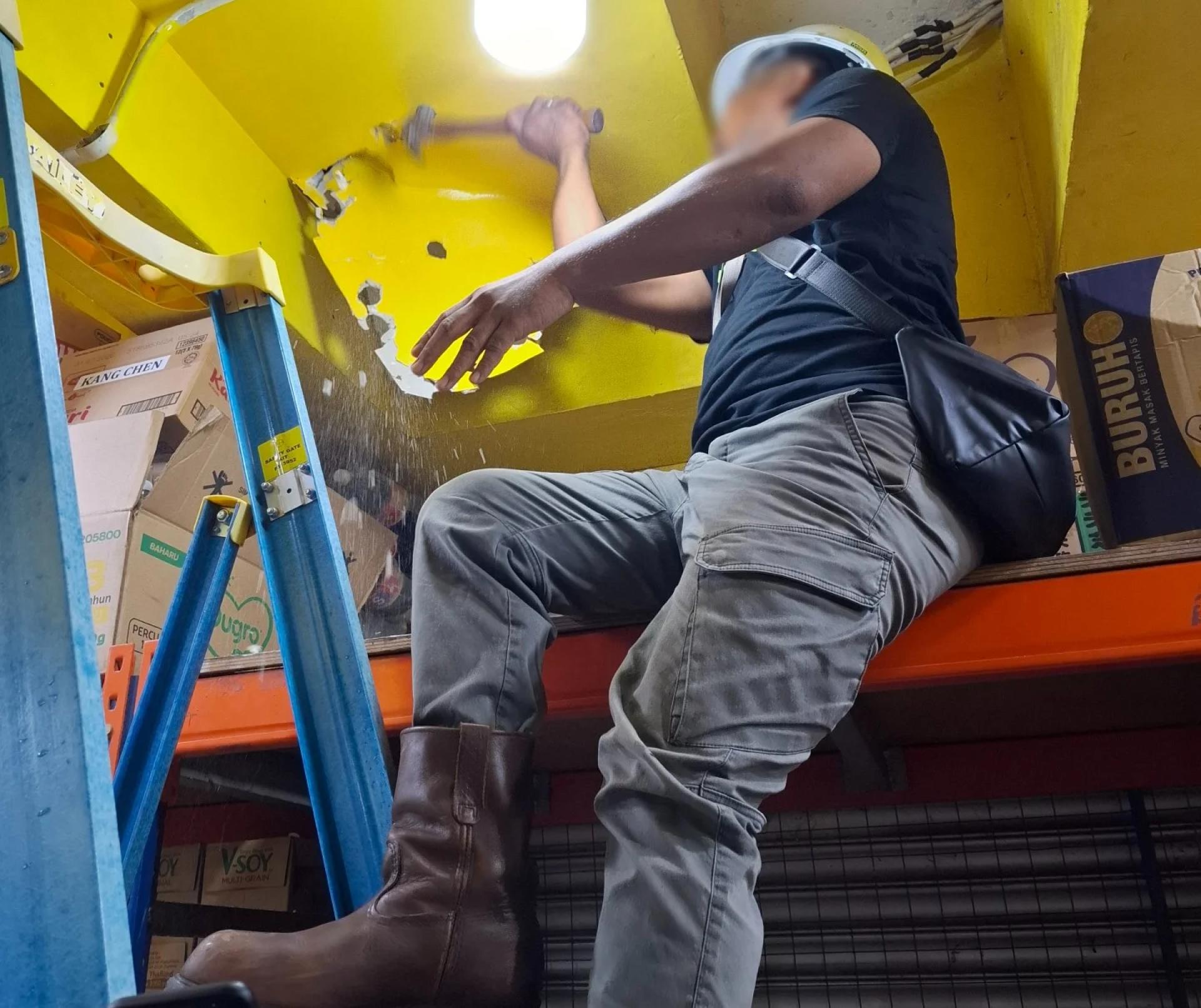 砂电力公司电表检查组拆除石膏板，揭露非法接电电缆。