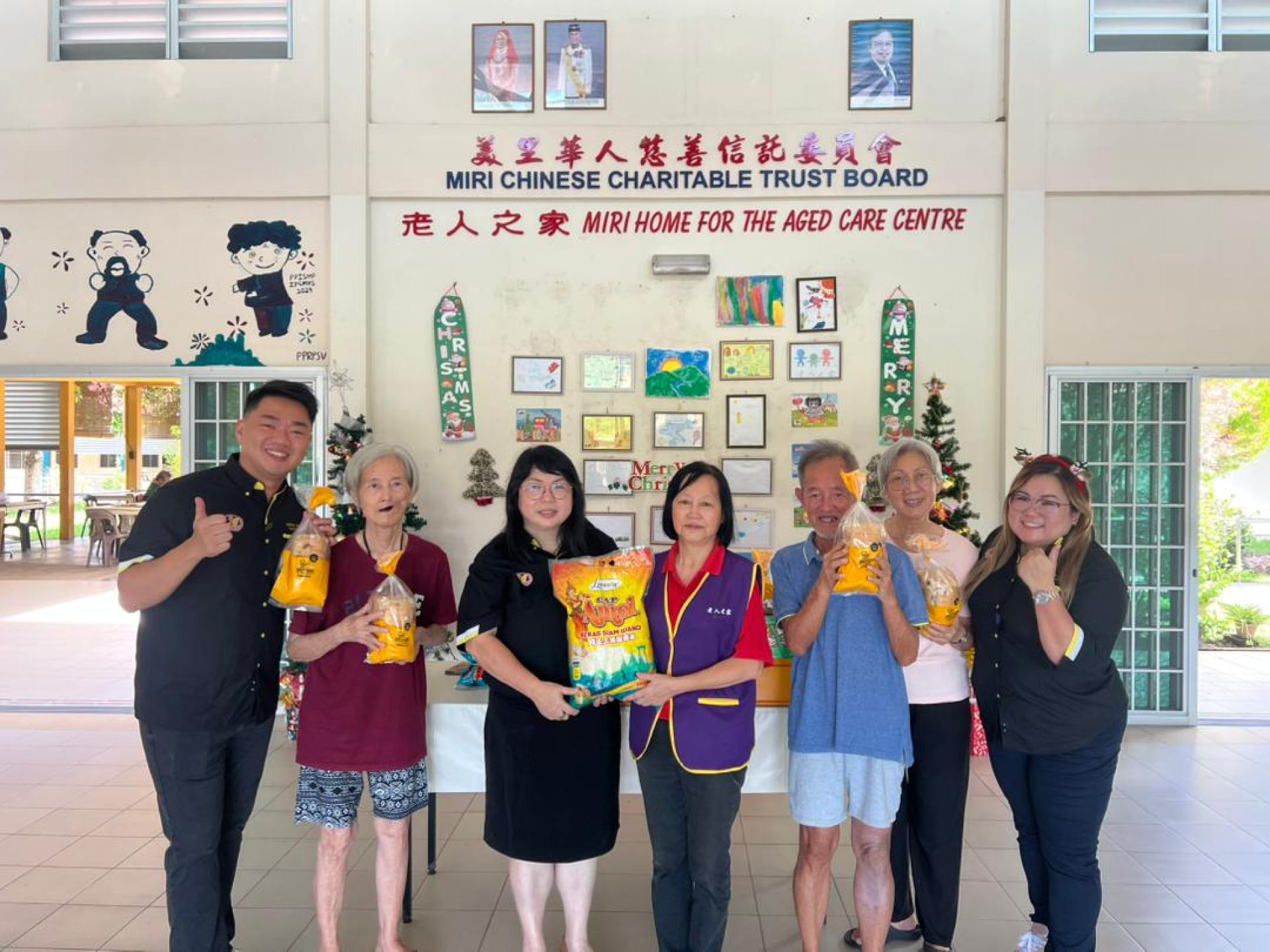 砂拉越华人公会青年团团长杨筌贻（左三）移交物资予美里老人之家负责人杨玉明后合影，左为砂拉越华人公会青年团组织李俊达。