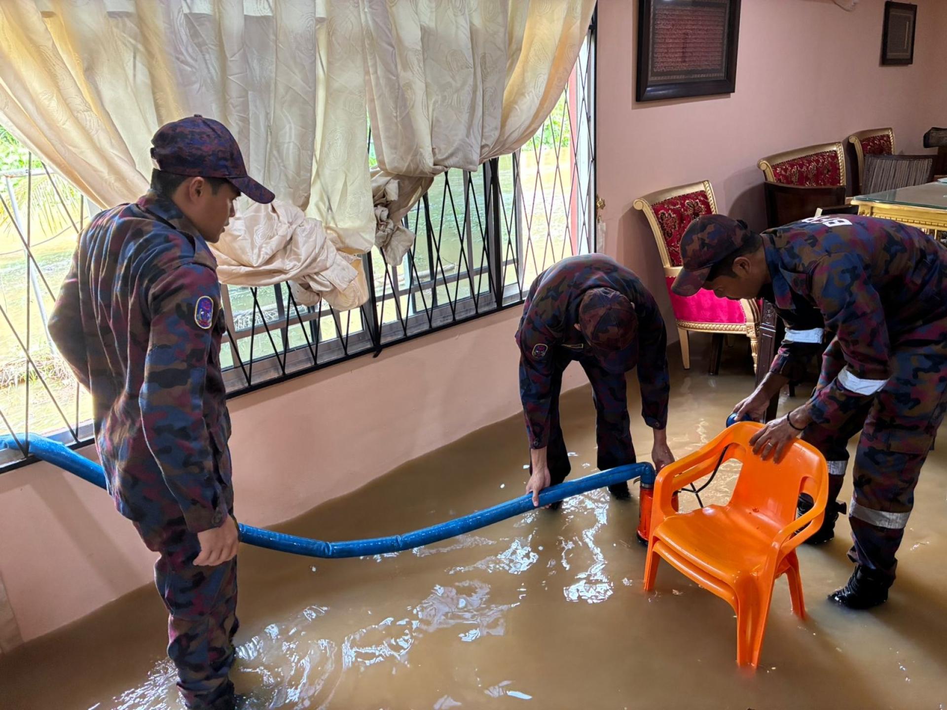 消防局官员协助住宅排水时影。