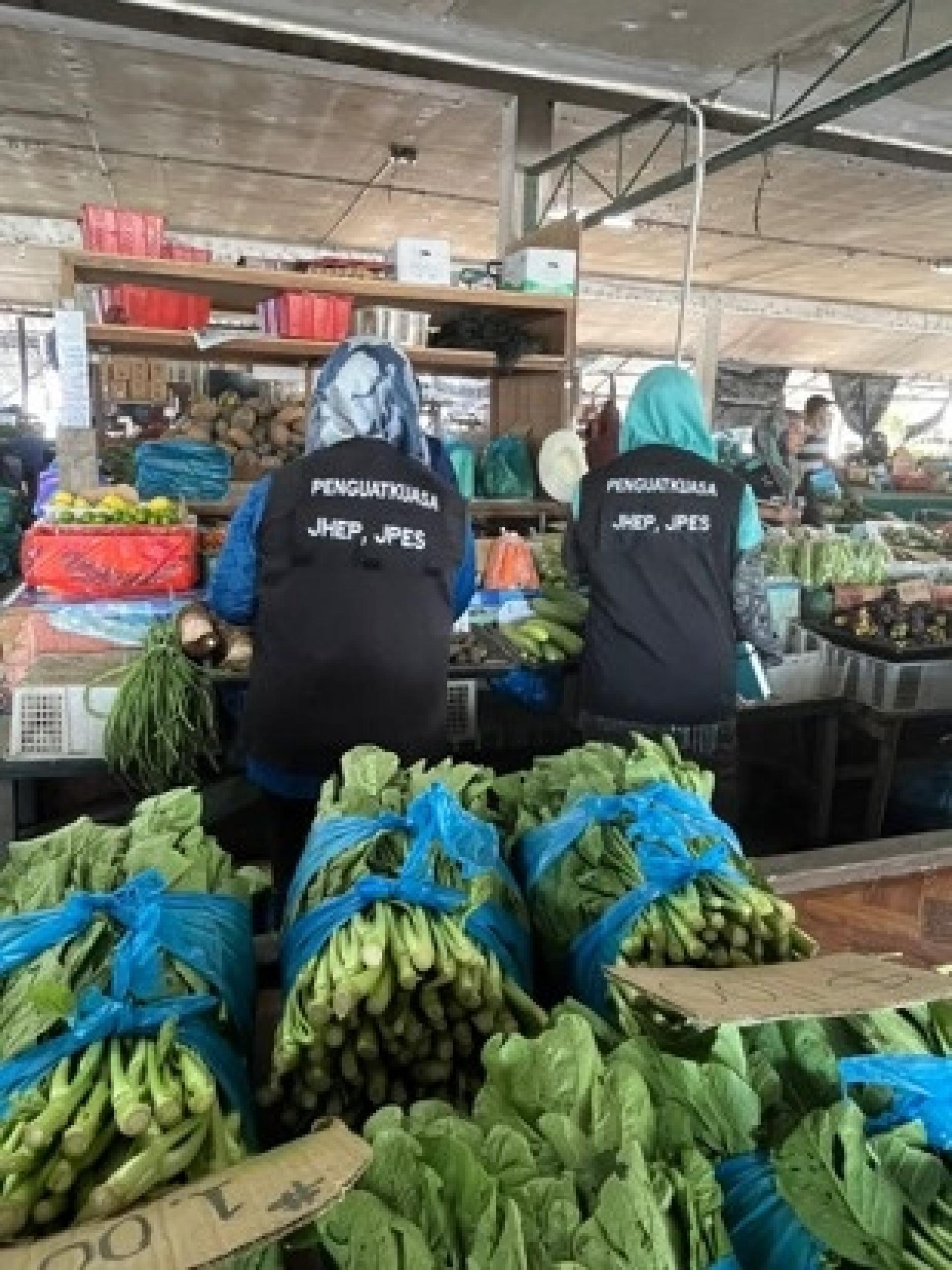 执法官员检查菜市时影。