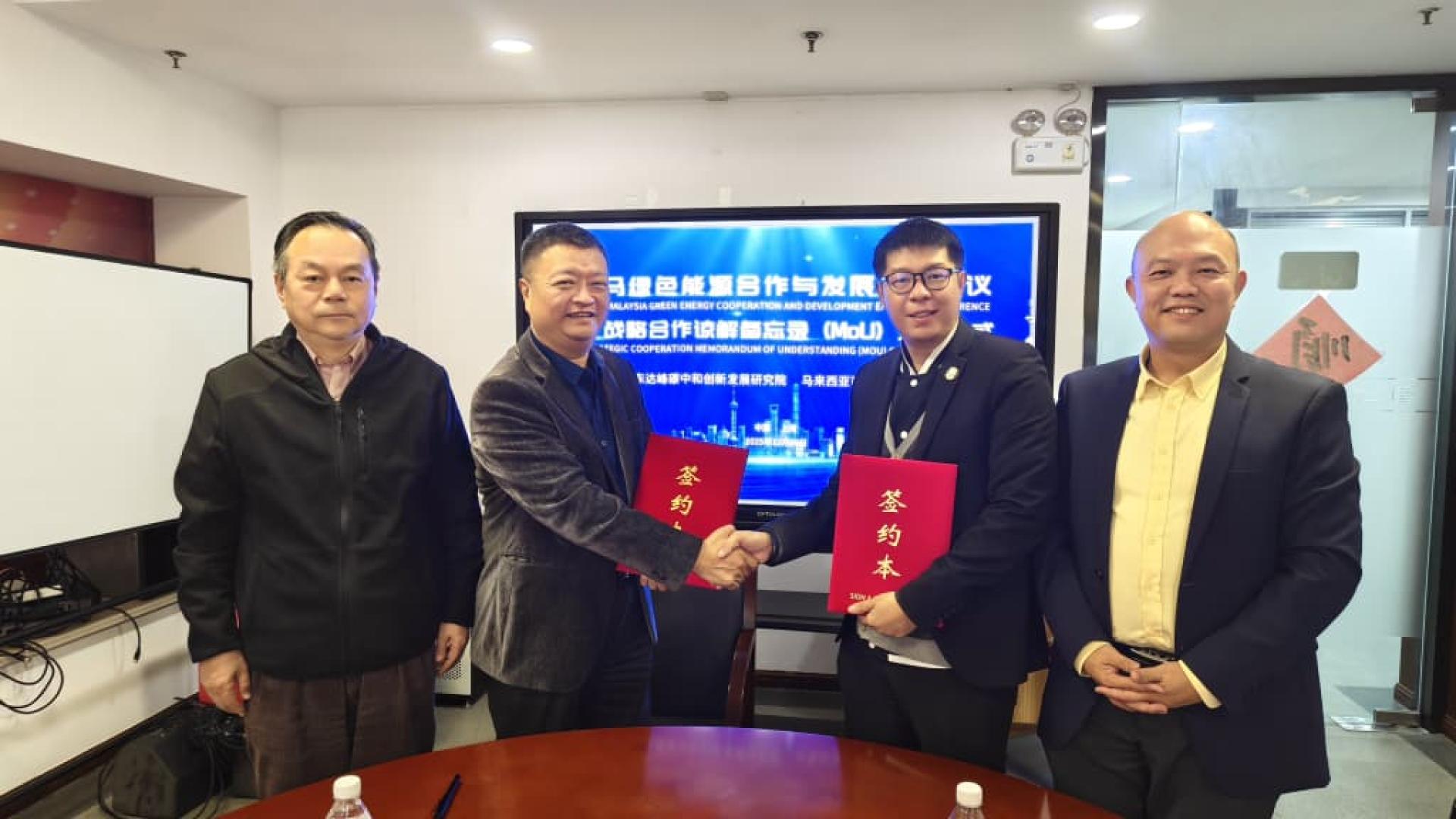 马来西亚可持续绿色能源协会（MSGEA）会长陈世骏博士（右2）和上海浦东达峰碳中和创新发展研究院(SPCNI)院长 顾骏（左2）交换双方所签署的合作备忘录。左1是上海市人民政府参事、浦东达峰院首席专家张兆安及马来西亚可持续绿色能源协会理事林智杰（右1）。