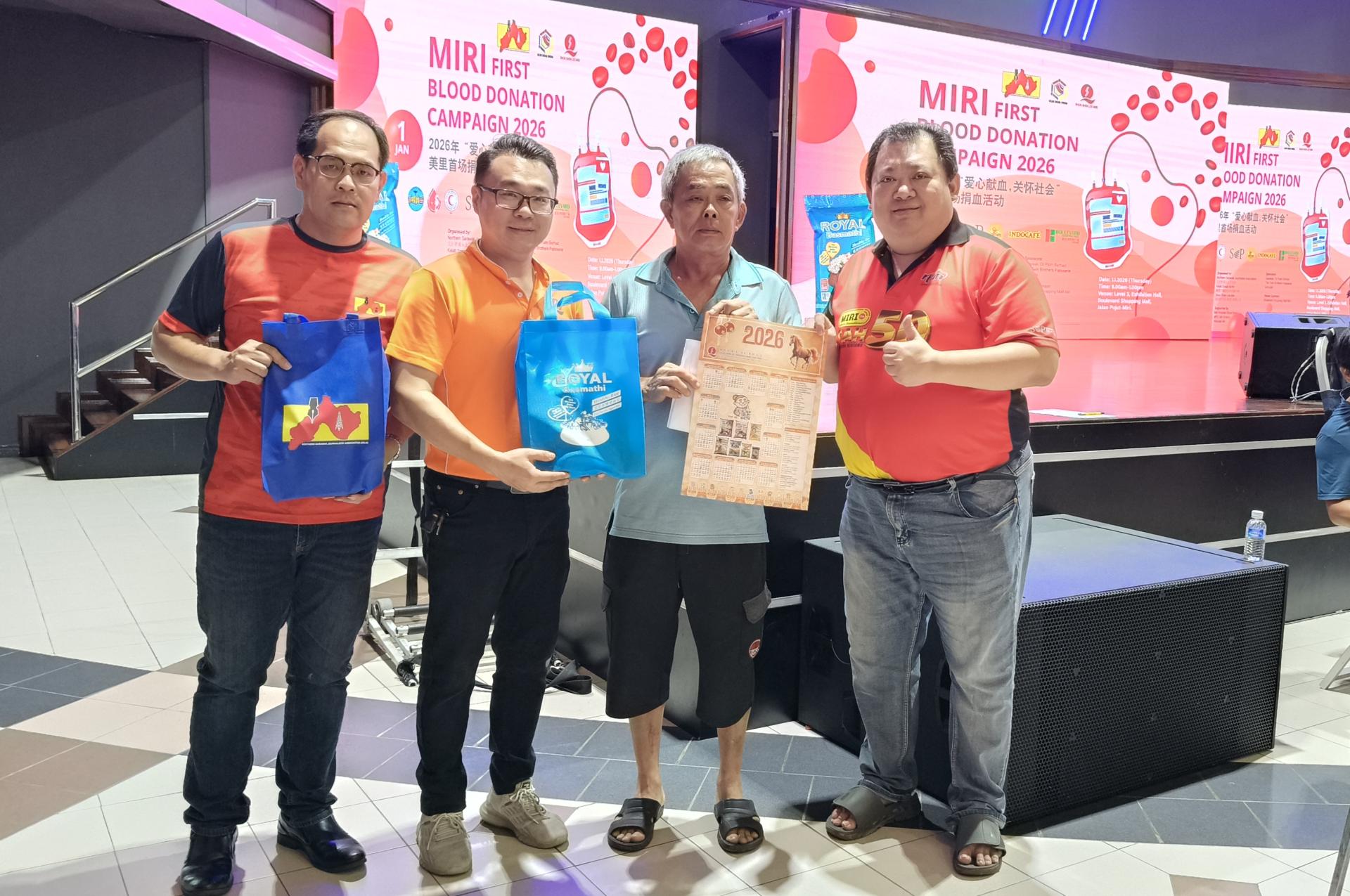 顺成利贸易（美里）有限公司经理余俊贤（左2）移交赞助品予2026年美里首场捐血活动的首名成功捐血者；左为筹备会主席兼北砂新闻从业员协会财政杨万勇，右为美里广播电台休闲俱乐部主席张旗何。