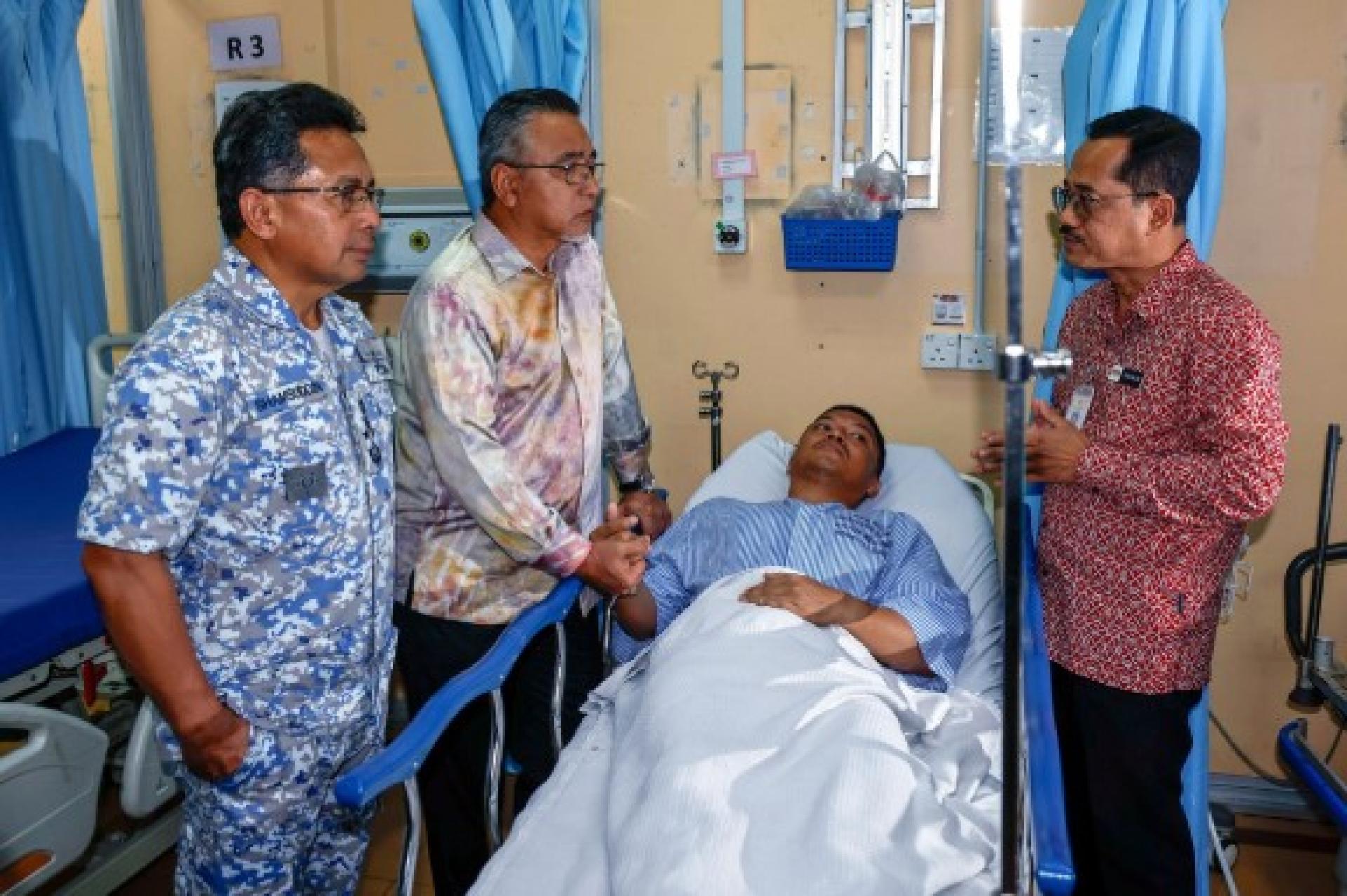 莫哈末祖菲卡（右2）因腰部和右小腿受伤，目前还在马六甲医院急诊及创伤部黄区接受治疗。图为国防部长副部长阿德里（左2）前往慰问伤者。