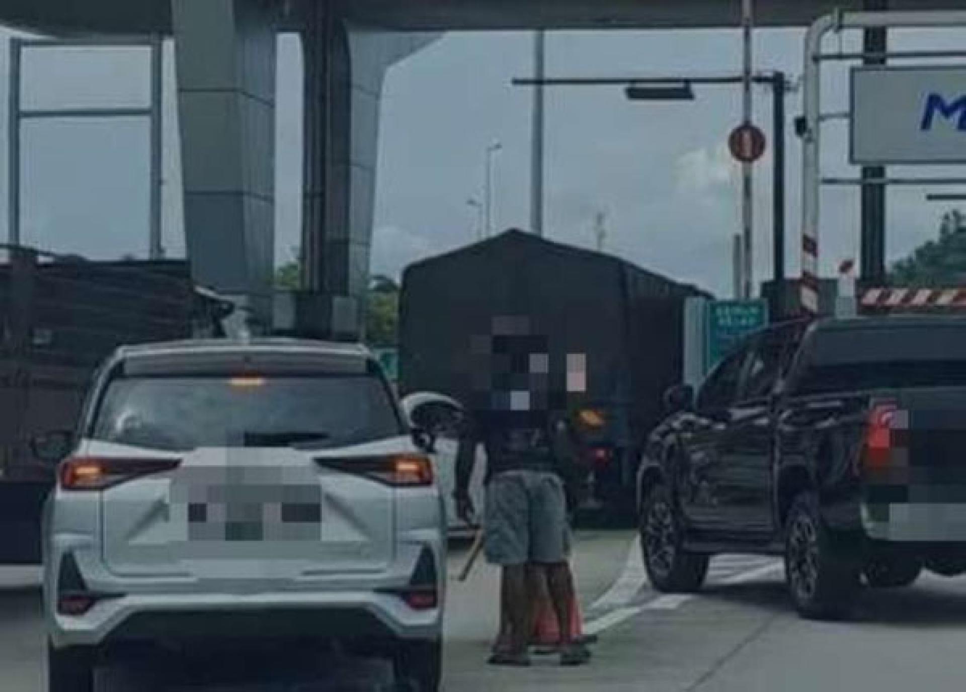 根据警方接获的投报，两名男嫌犯在收费站前滋事，其中1人还手持木棍，导致车辆通行受阻。