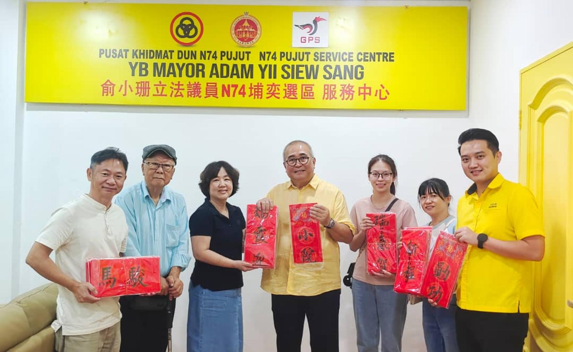 美里书艺学会会长甘美美（左3）移交春联予埔奕区州议员兼美里市长俞小珊（右4）；左2为该会名誉会长陈乃豪老师。