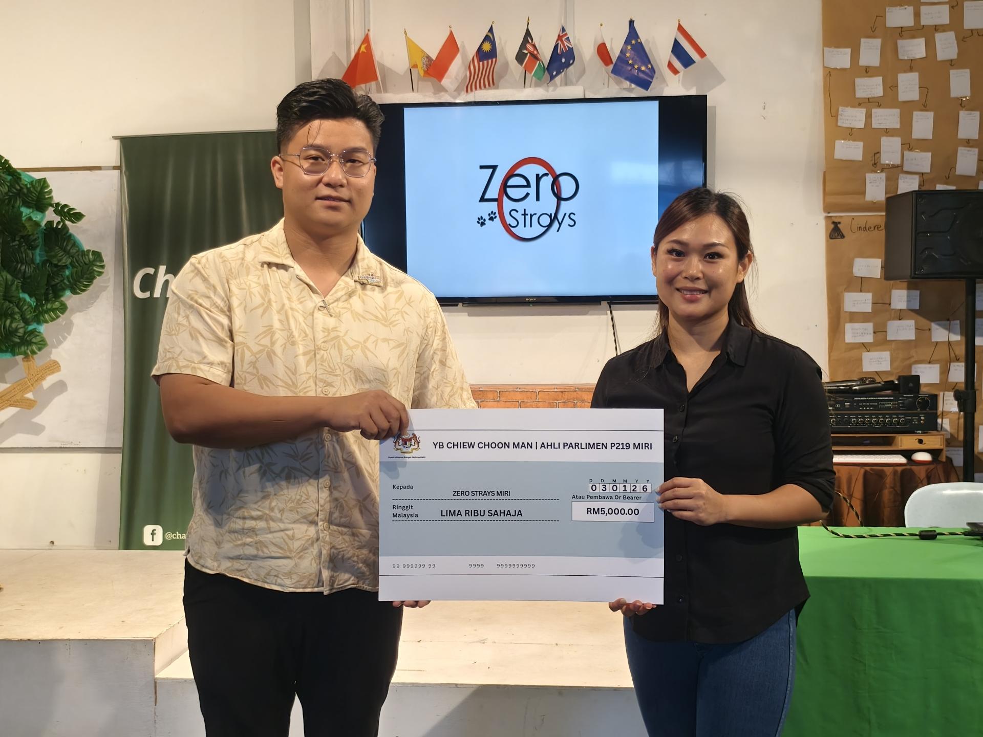 美里国会议员秘书兼公正党美里区部宣传主任邹梓建（左）移交赵俊文所拨出的5000令吉捐款予零流浪生命协会主席许菀玲。