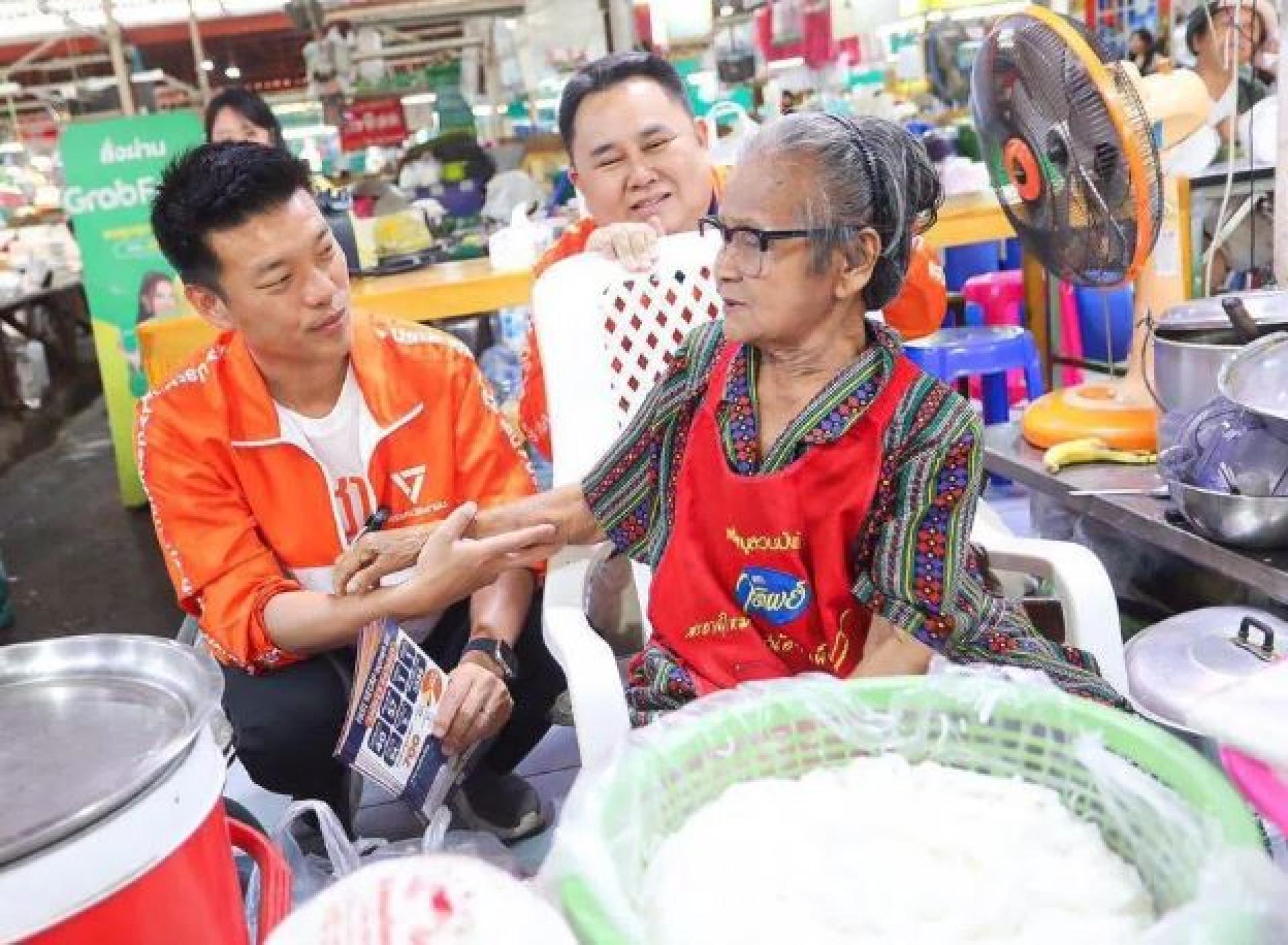 人民党党魁那他蓬（左）周五率领竞选团队在呵叻府走访社区，与选民互动拉票，为来临大选争取支持。