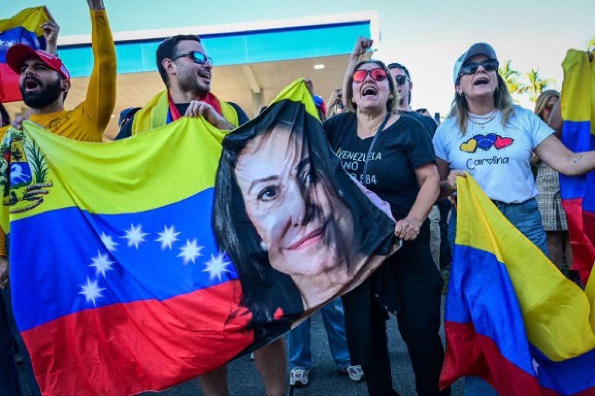 佛罗里达州迈阿密，人们挥舞着印有诺贝尔和平奖得主马查多照片的委内瑞拉国旗。
