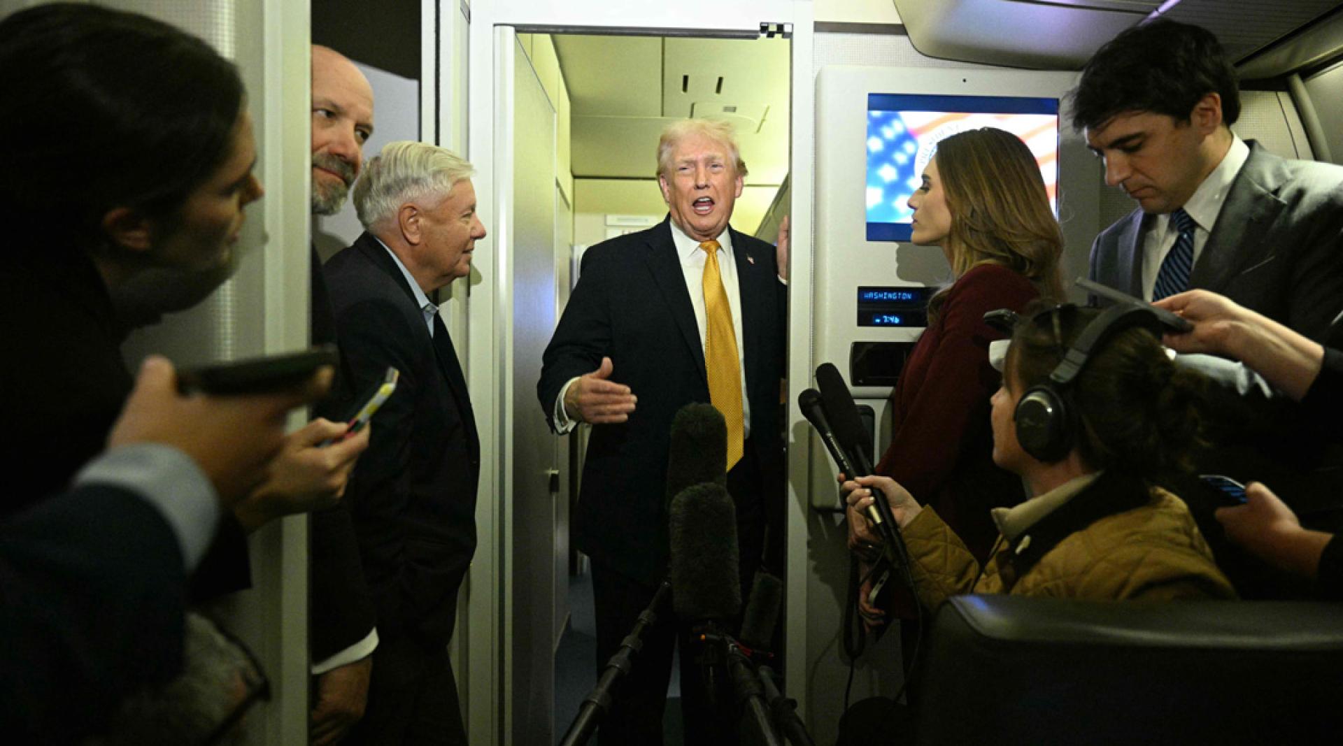 特朗普在空军一号上回应媒体的提问。