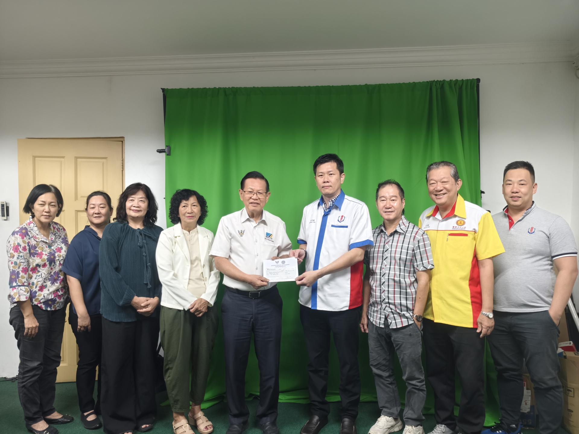 砂拉越交通部长兼史纳汀区州议员拿督斯里李景胜（左5）移交拨款给美里省华人社团联合会会长许信隆，作为2026年第5届拿督斯里李景胜博士挑战杯北砂区中小学暨公开挥春比赛经费。图左4为筹备会主席许美链。