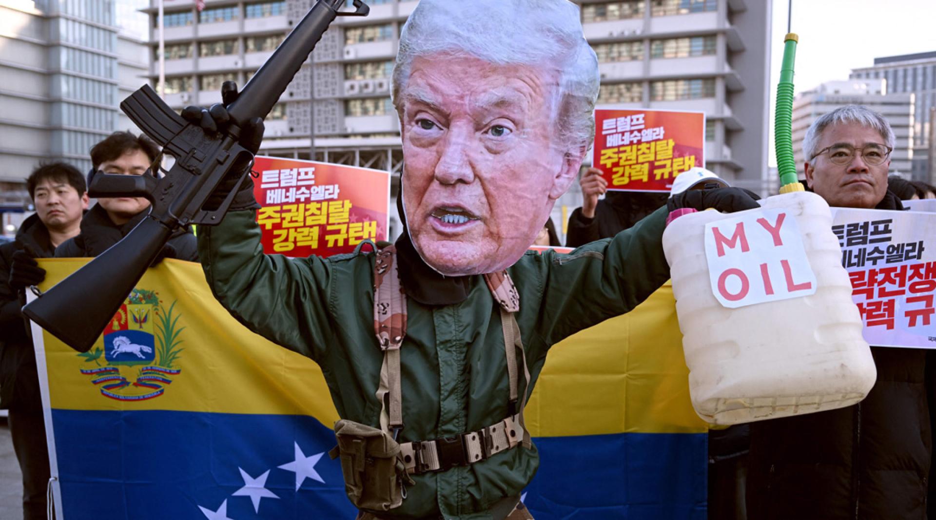 5日在韩国首尔美国大使馆前，一名戴着美国总统特朗普面具的抗议者在示威活动中表演，谴责美国对委内瑞拉的军事行动。