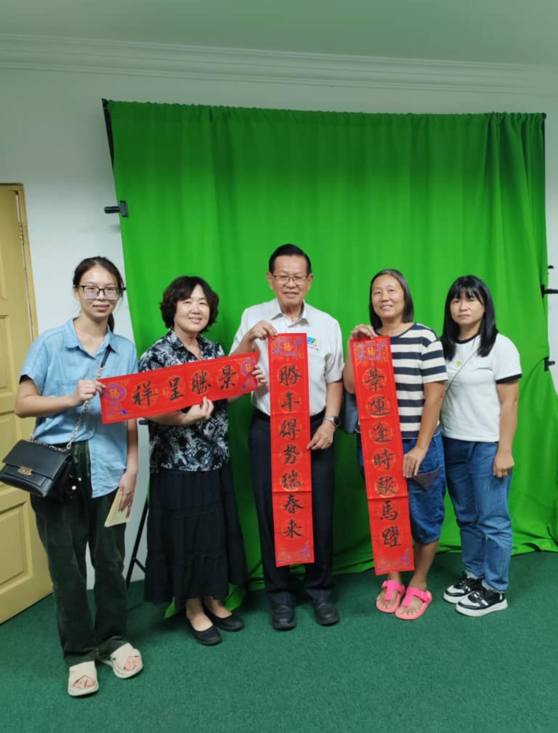 美里书艺学会拜会砂拉越交通部长拿督斯里李景胜并移交活动邀请函，同时赠送一幅以交通部长名字冠顶的春联。左起为筹备会主席温思捷、会长甘美美；右1及右2为该会理事叶眀依与许华珍。