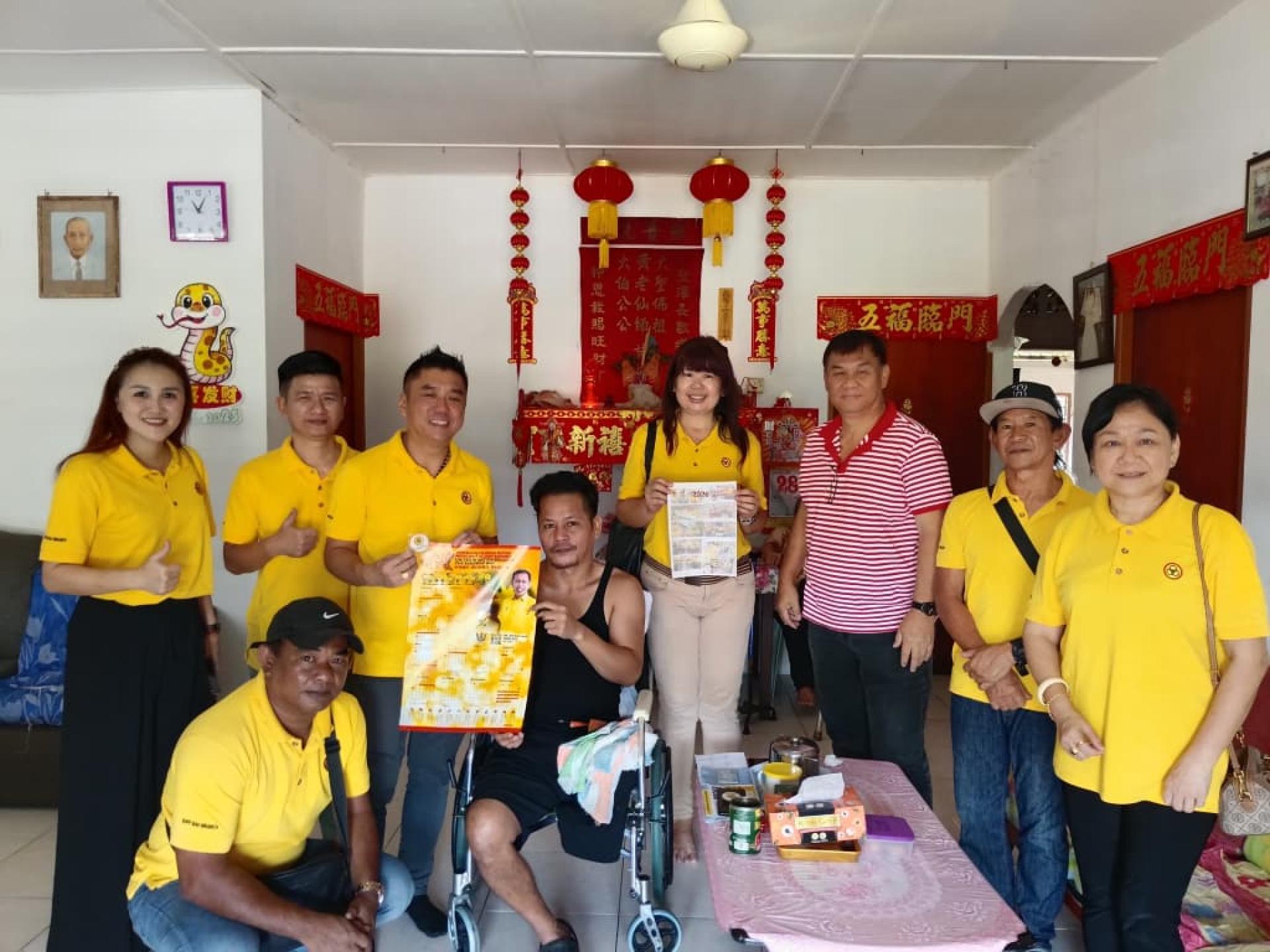 人联党石隆门支部流动服务团队与社区领袖甲必丹何文辉及家庭成员合影，并向家庭赠送年历。
