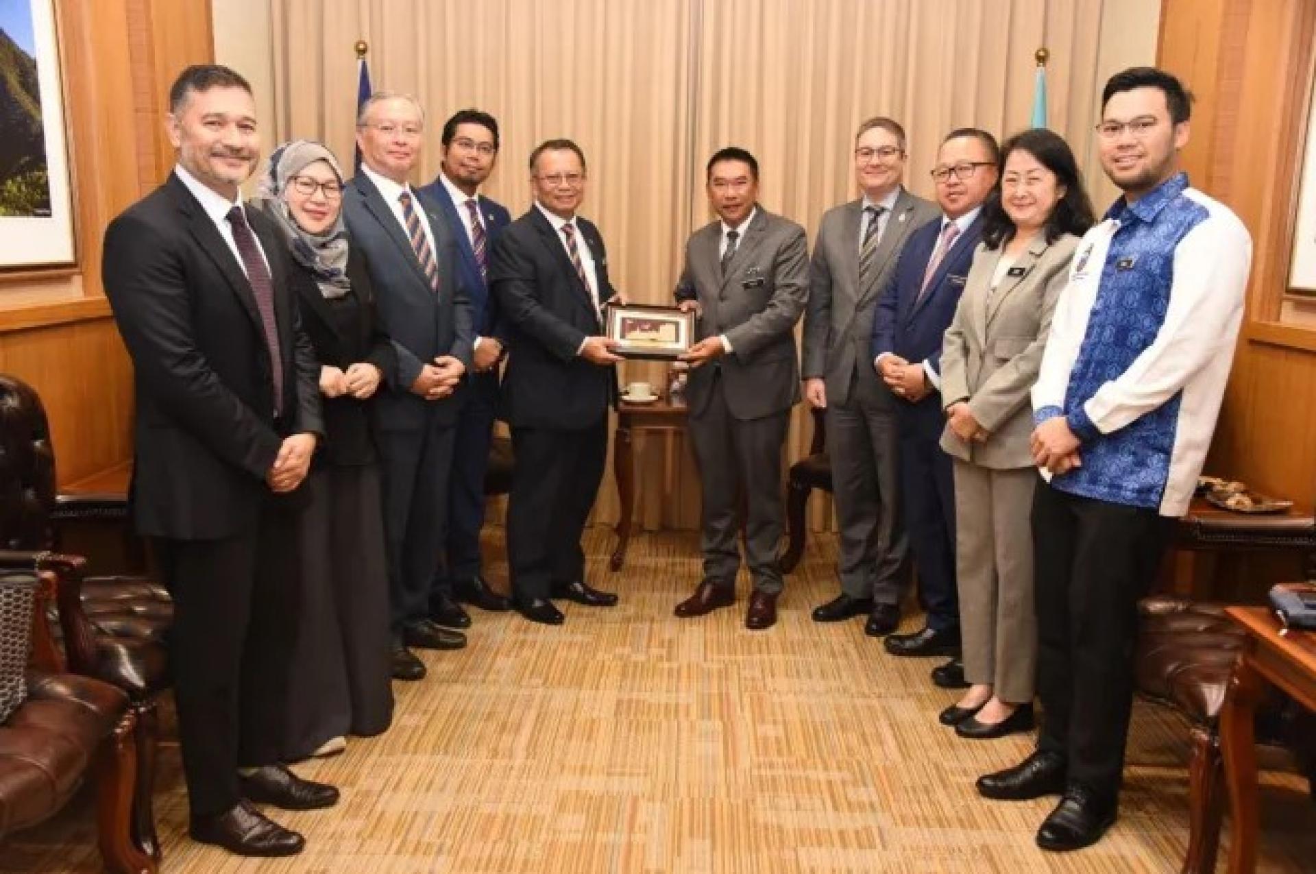 2026年1月8日，阿布巴卡（左5）在京那巴鲁大厦礼貌拜访沙巴州秘书时，向沙法尔赠送纪念品。