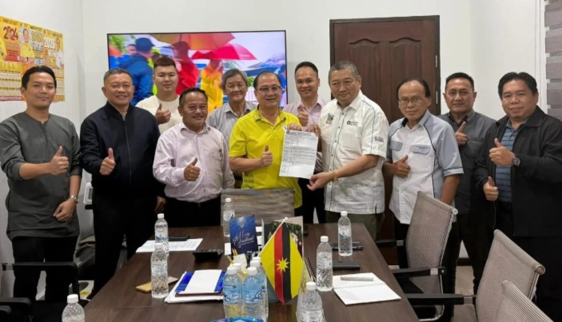 Jumaat与Samri一同将民都鲁区童军理事会主席委任书移交给潘隆铭。