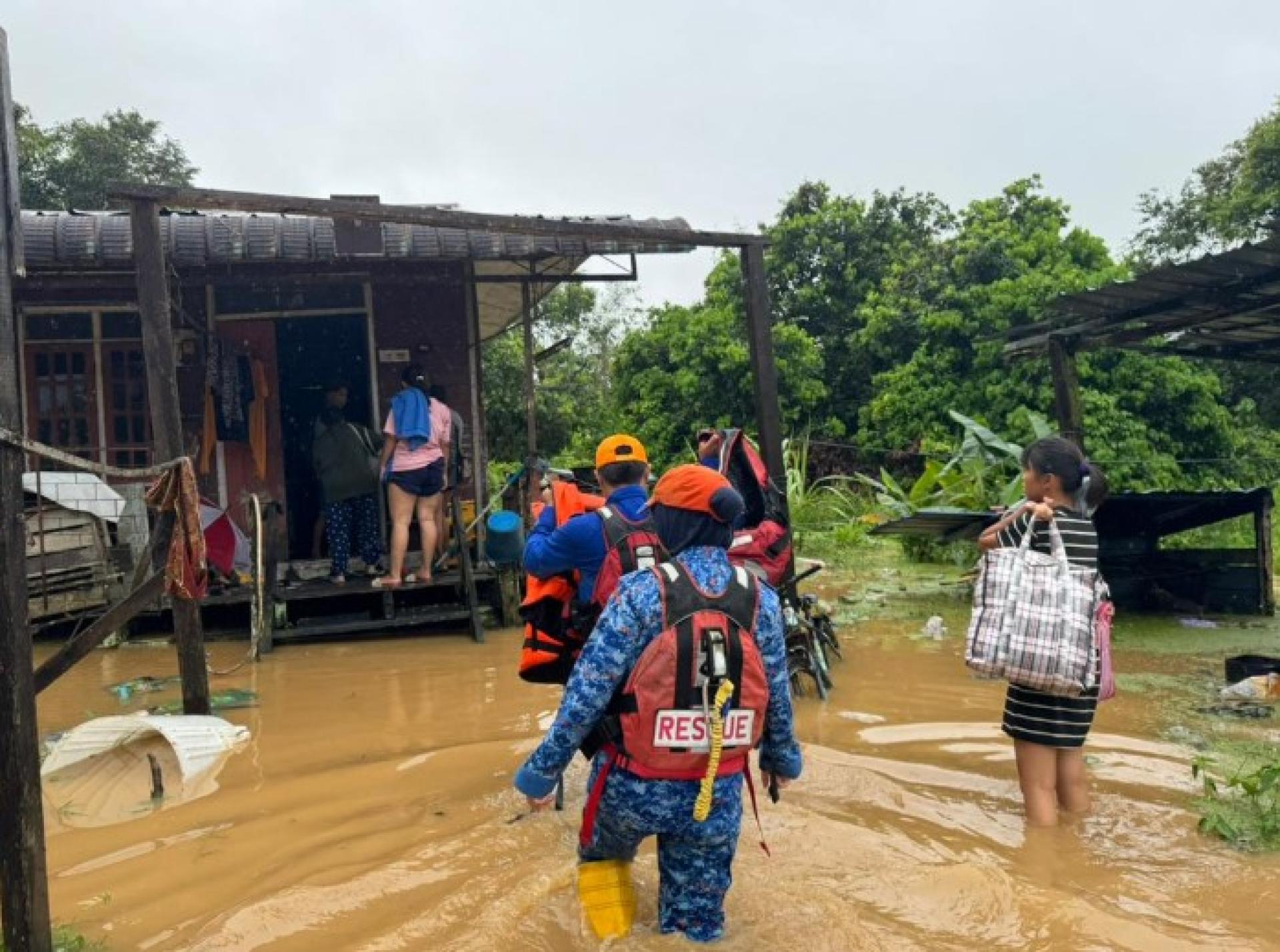民防队员协助洪灾受灾民众转移至诗巫甘榜Jeriah礼堂临时疏散中心。