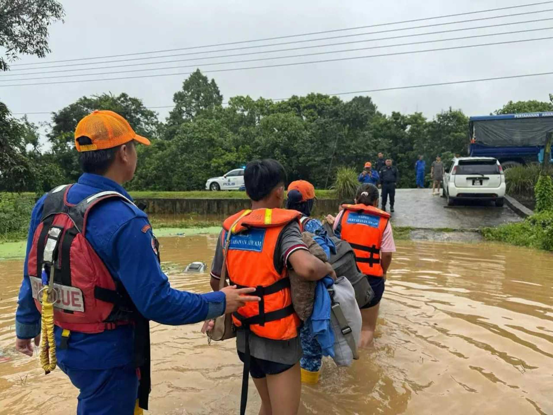 部分受影响的灾黎，在救灾人员协助下，前往临时迁移中心。