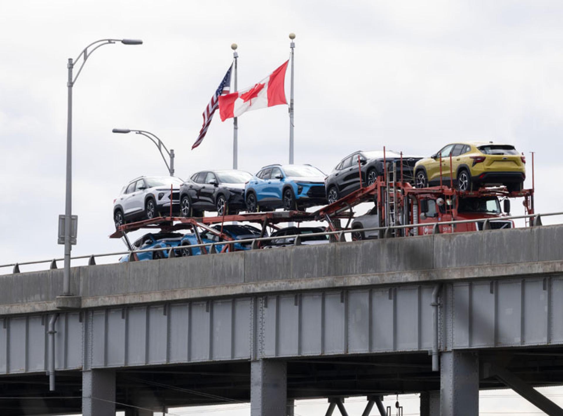 在加拿大安大略省尼亚加拉瀑布市加美边境地带，一辆满载的汽车运输车通过刘易斯顿-昆斯顿桥开往加拿大。（图：新华社）