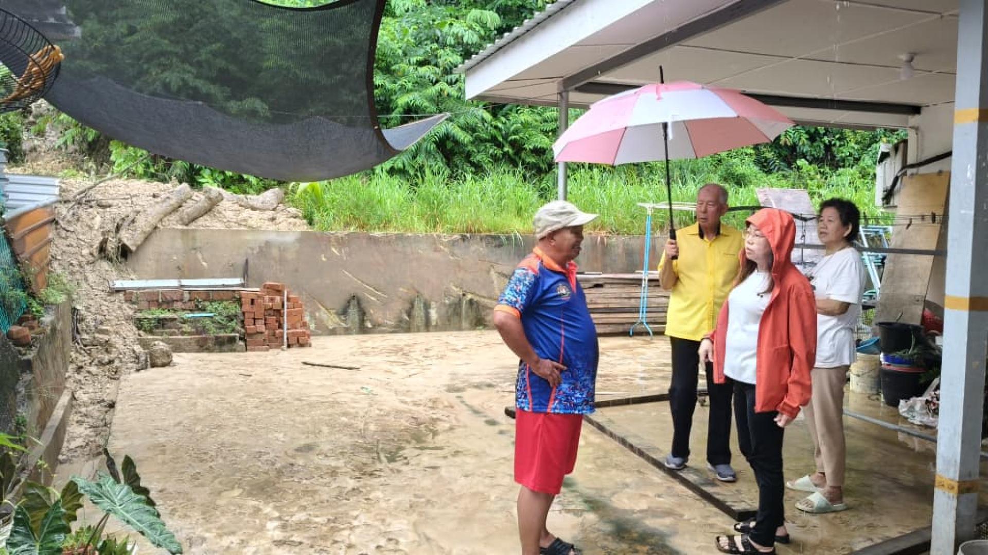 砂旅游副部长拿督陈超耀（中）巡视其中一间遭山体滑坡影响的住家后院。