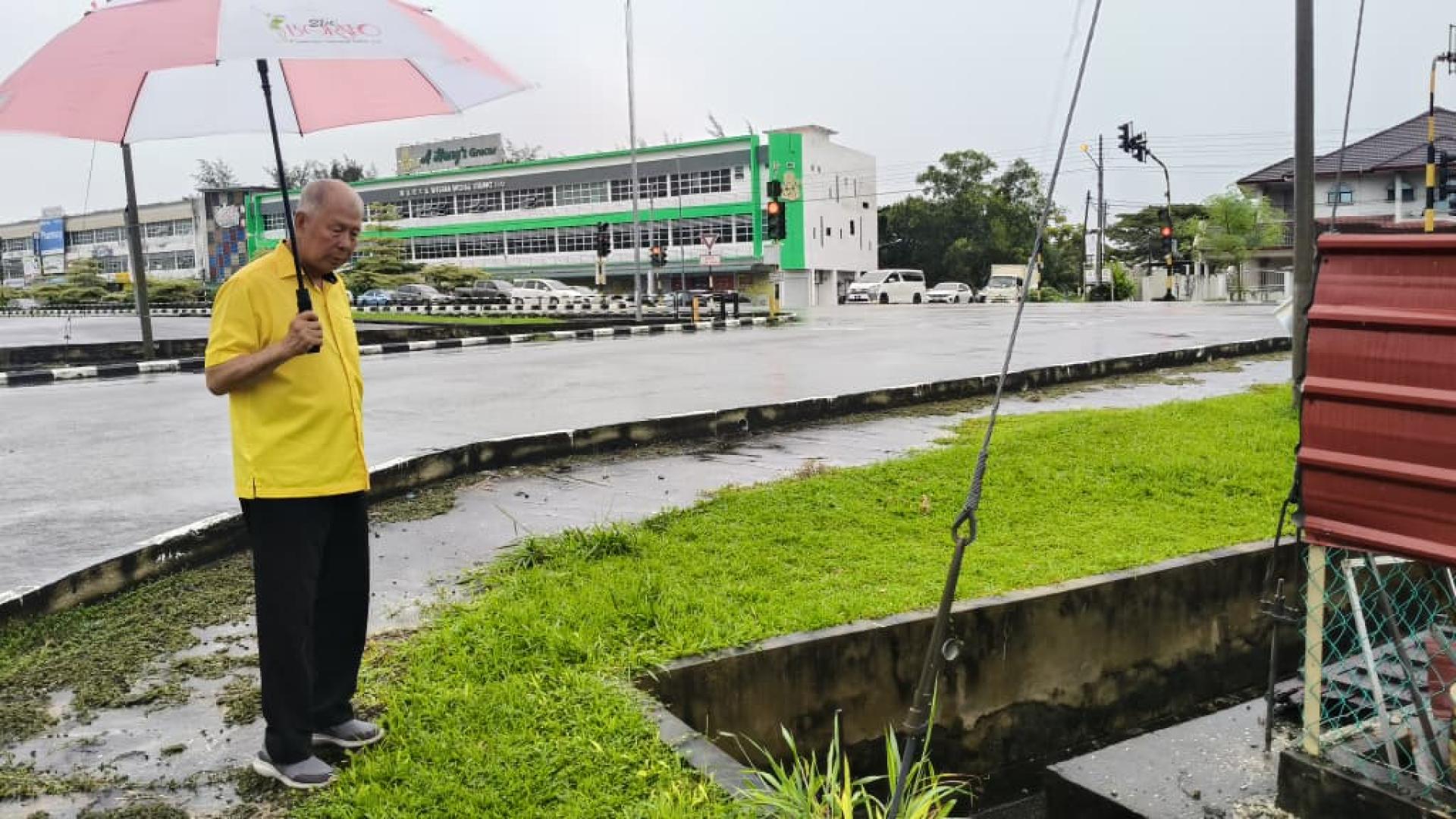 陈超耀在甘榜鲁哇了解当地住宅区的排水沟状况。