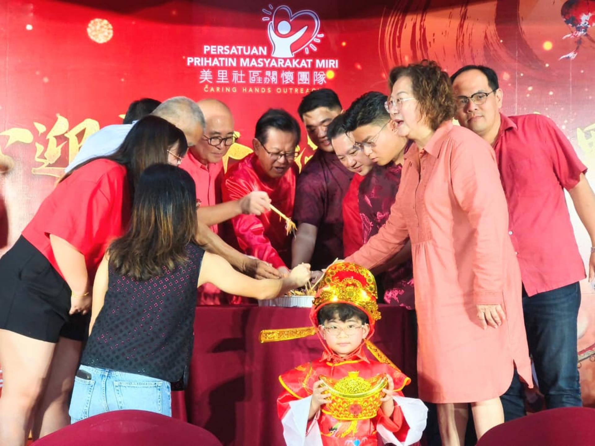 嘉宾们在宴会上进行捞生仪式，寓意来年捞得风生水起。