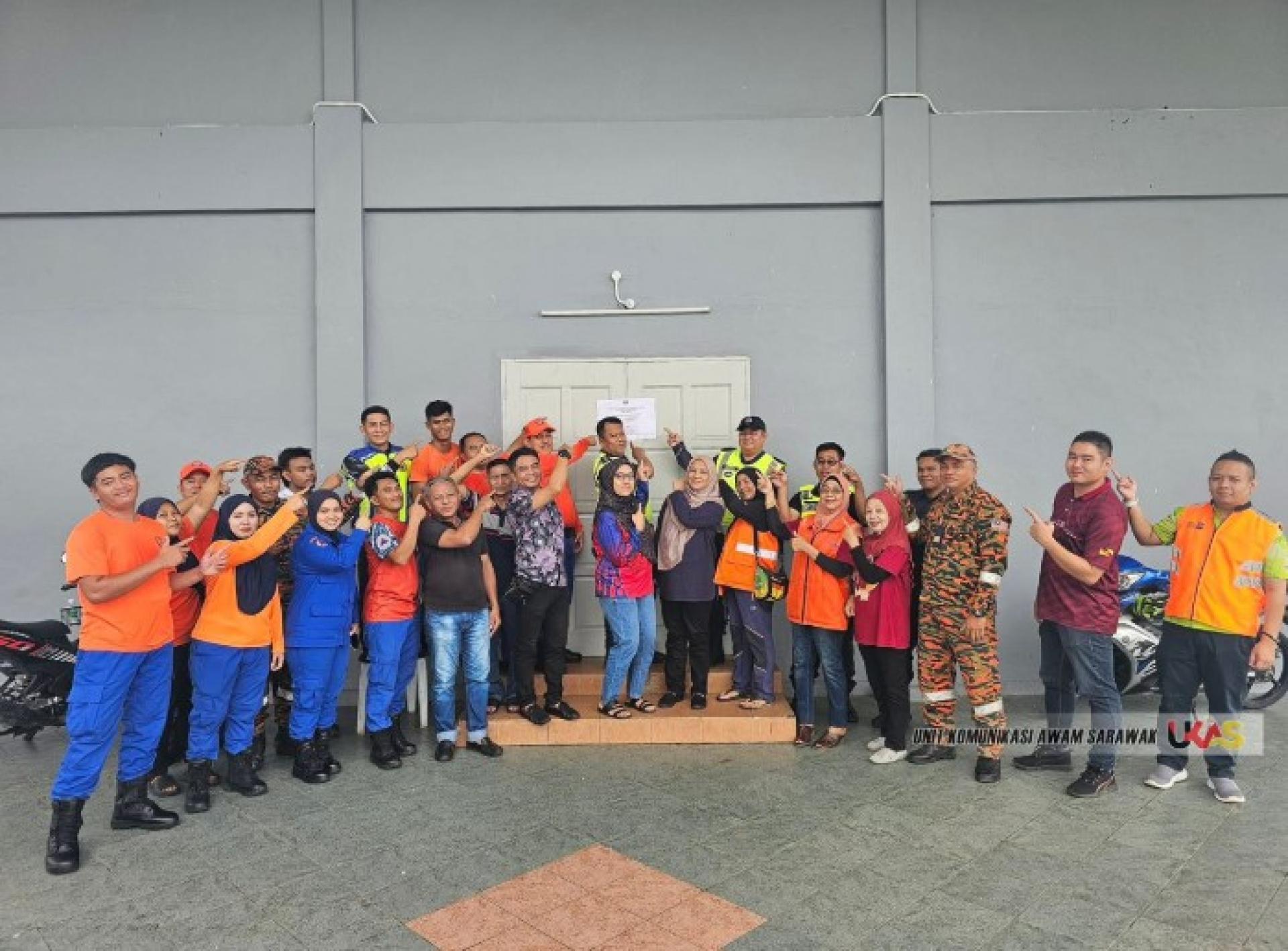 沙努亚（中）在实文然亲善礼堂临时避难所与工作人员合影。