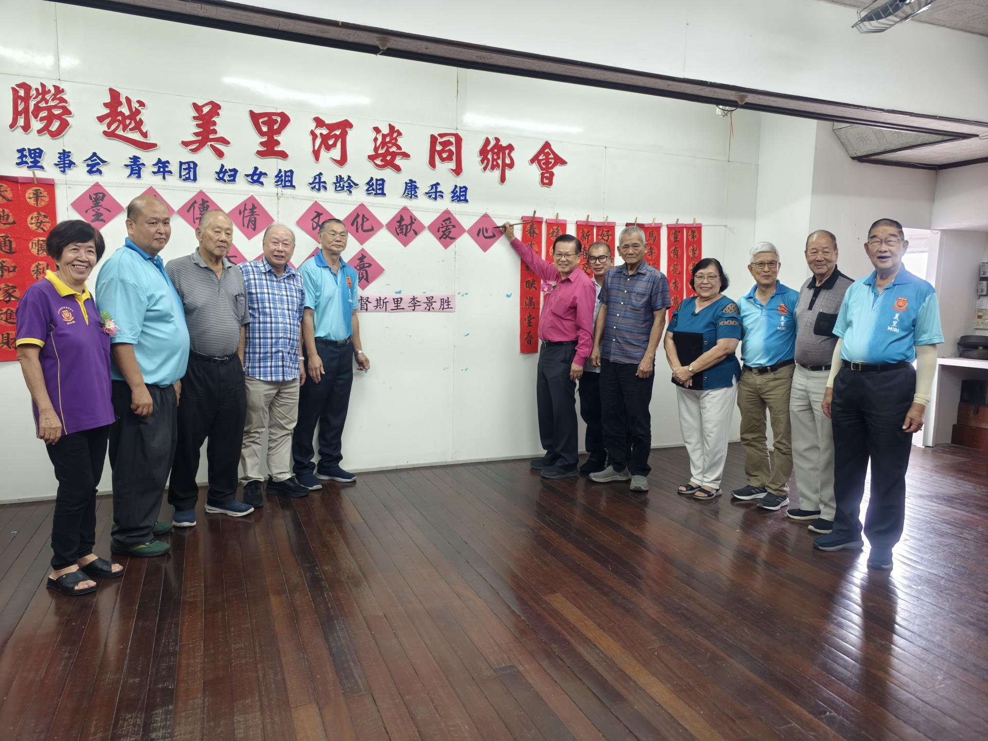 砂拉越交通部长拿督斯里李景胜为砂拉越美里河婆同乡会《墨韵传情、文化献爱心》春联义卖活动主持推展礼。左5为会长蔡传创。