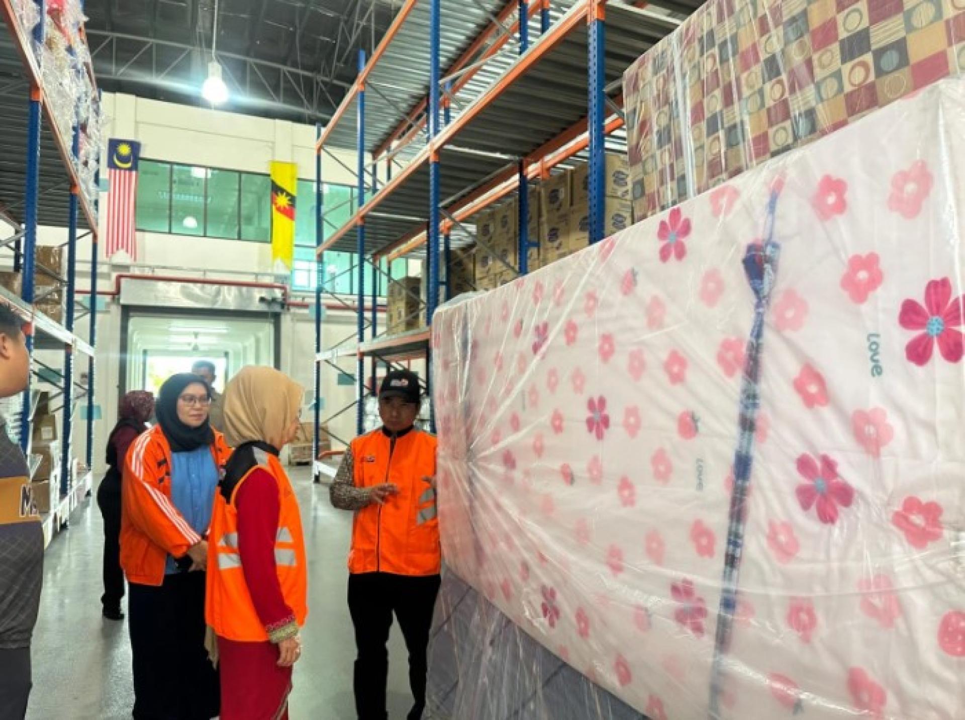 陈赛明视察灾害储备仓库中的床垫等基本用品。