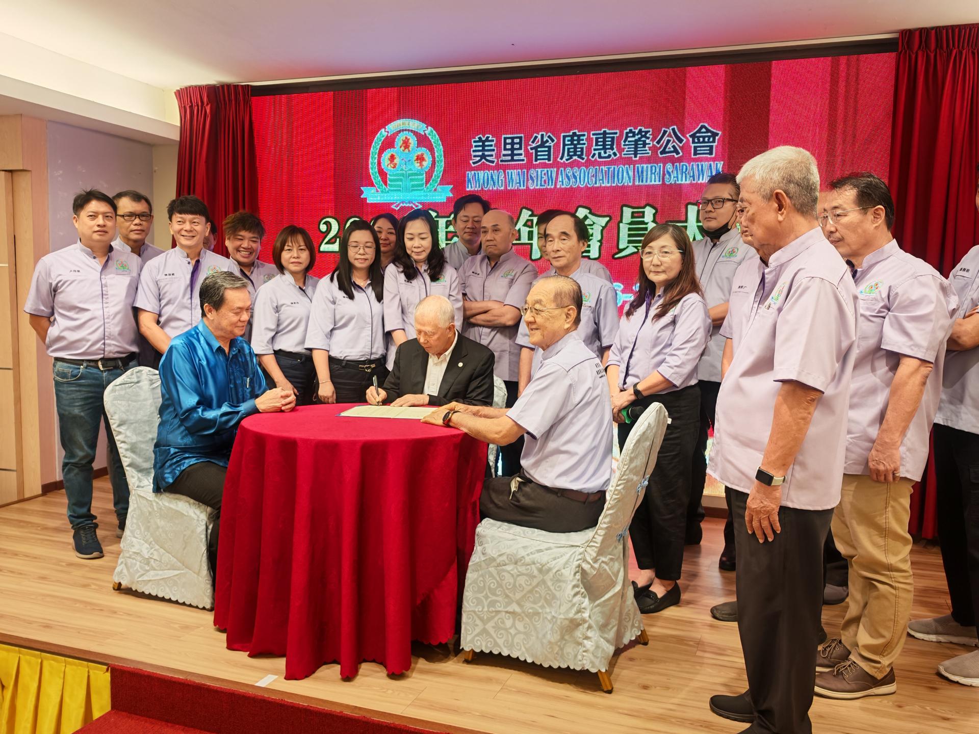 监誓人拿督陈超耀在美里省广惠肇公会2026至2027年度理事宣誓就职宣誓书上签名。左为名誉会长本曼查冯兆明，右为会长黄运祥。
