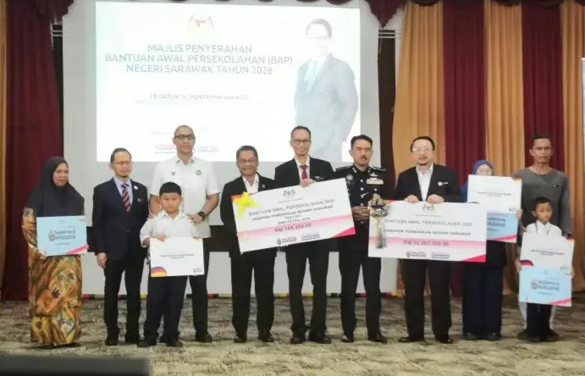 穆斯达法（左5）于2026年1月12日在古晋SMK Petra Jaya举行的BAP 2026发放仪式上，与出席者合影。