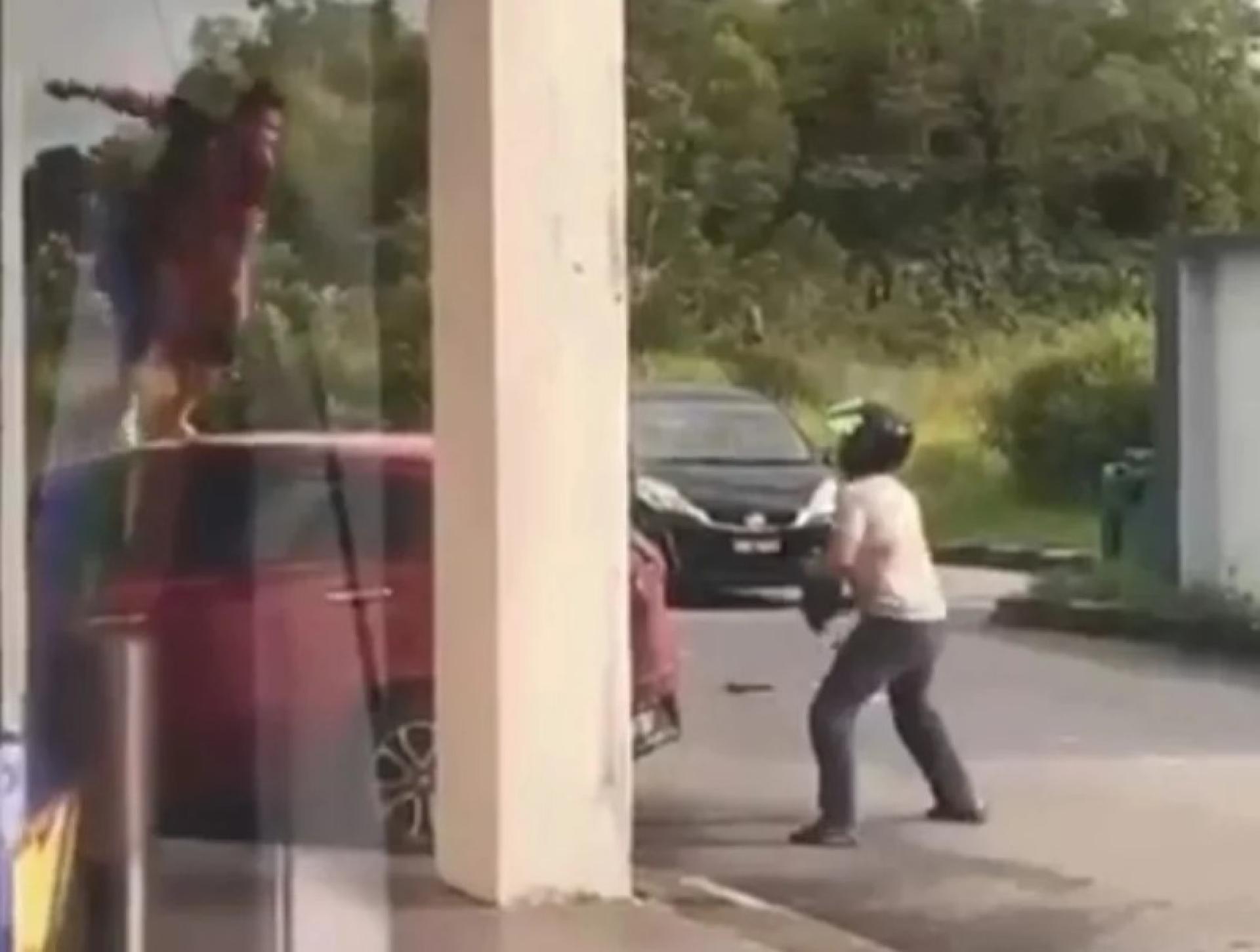 疯传视频截图显示两名男子在公共场所持砍刀对峙。