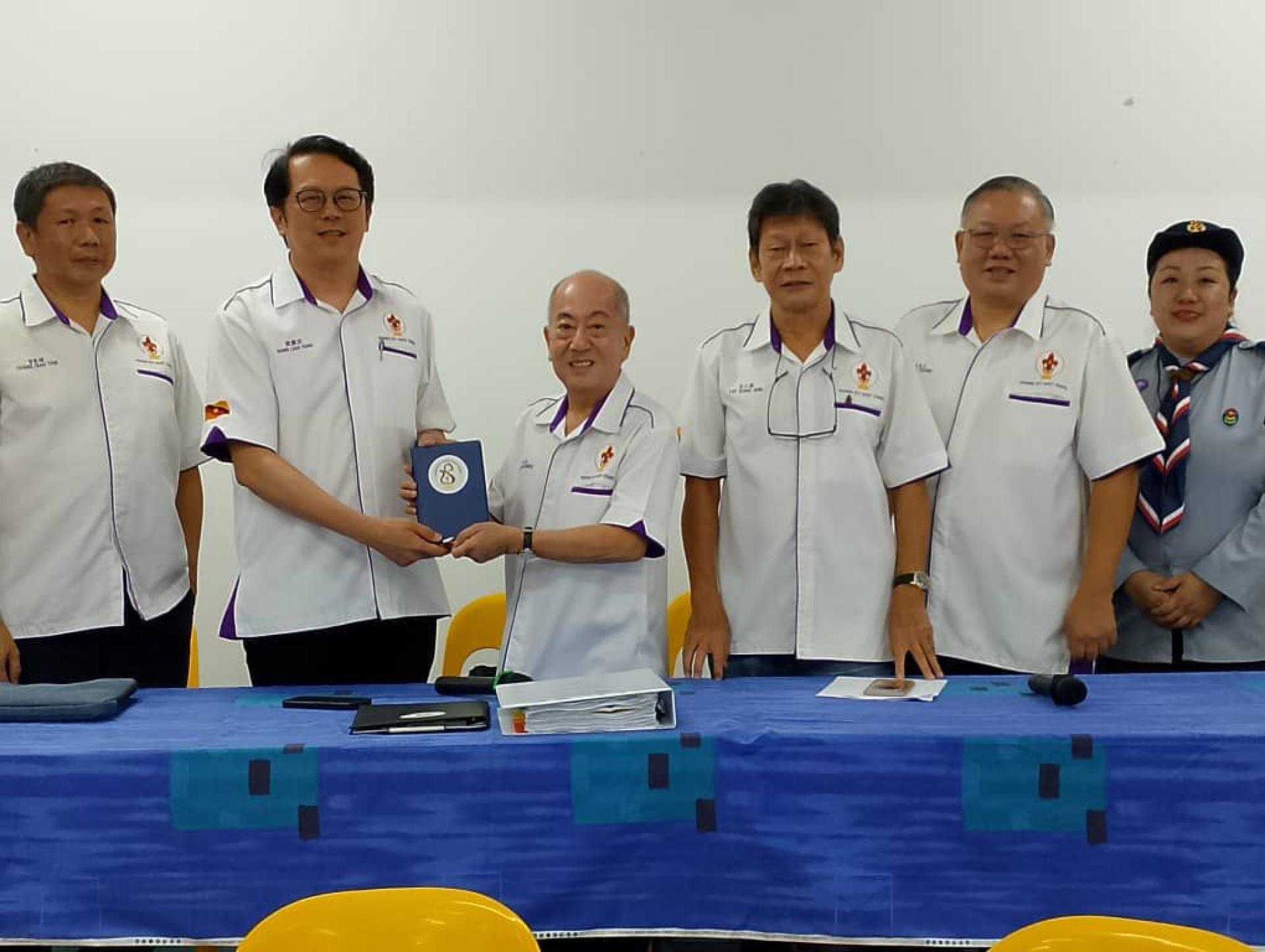 张燕石（左3）将古晋市童军协会会所钥匙移交予新任主席黃廉欢。(左起) 财政曾宪耀，会长李江勝，秘书张彼得，总监廖美珠。