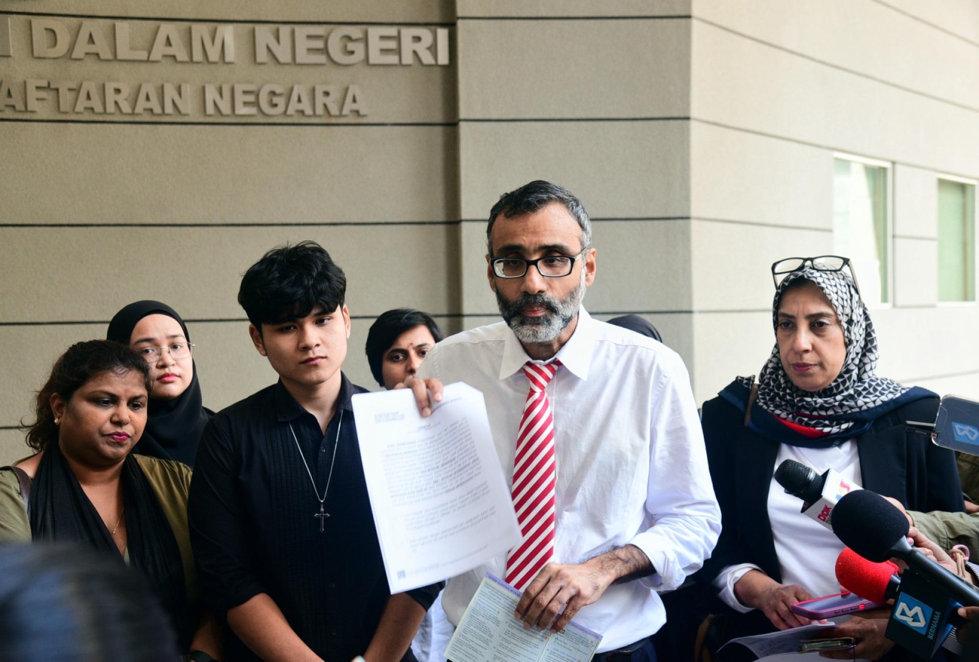 苏仁德兰（右2）及拉蒂花（右）陪同青少年到布城国民登记局总部办理大马卡的申请。