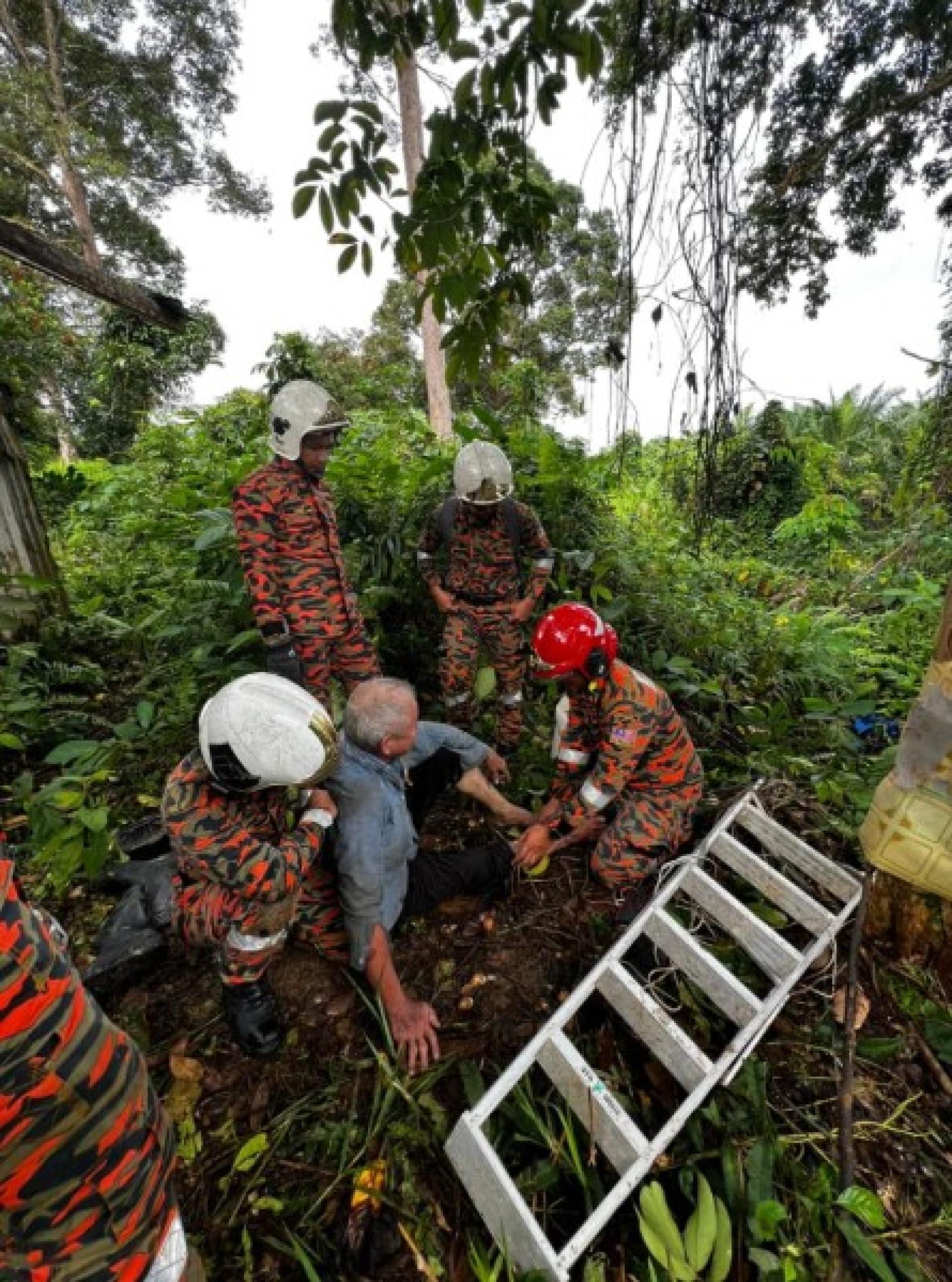 消防员将受困男子从树上放下。