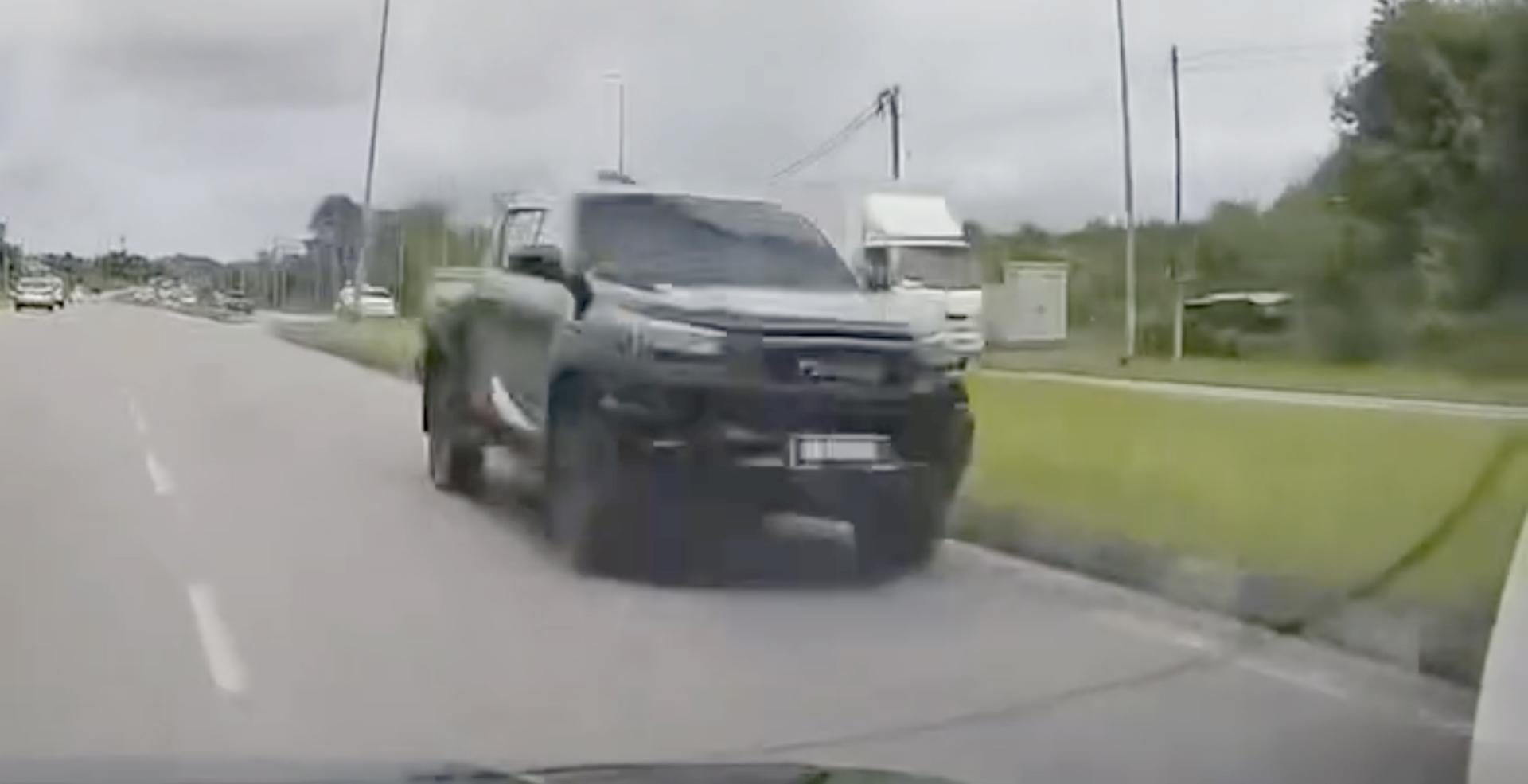 一辆四驱车在公路上高速逆向行驶，更闪高灯要求其他车辆让路。