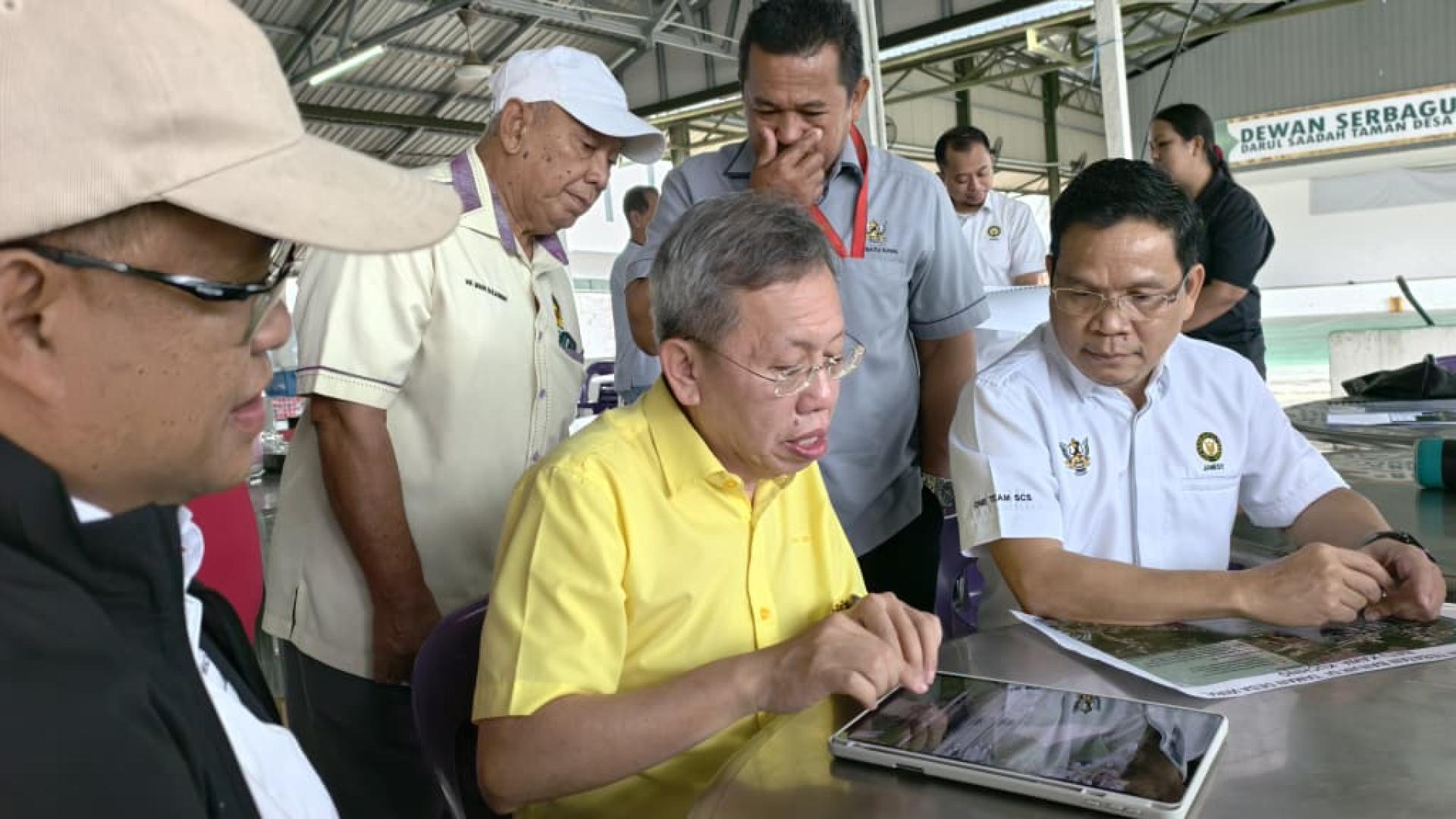 沈桂贤听取砂水利灌溉局官员提呈的工程汇报。