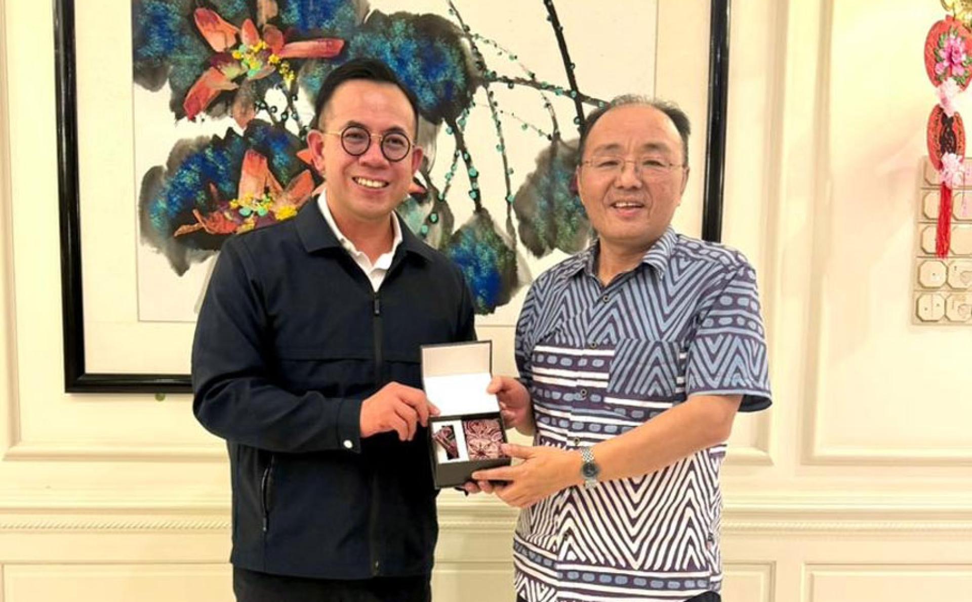沈志强（左）将大马本土品牌 Kapten Batik 的领带及口袋巾套装赠予欧阳玉靖大使。