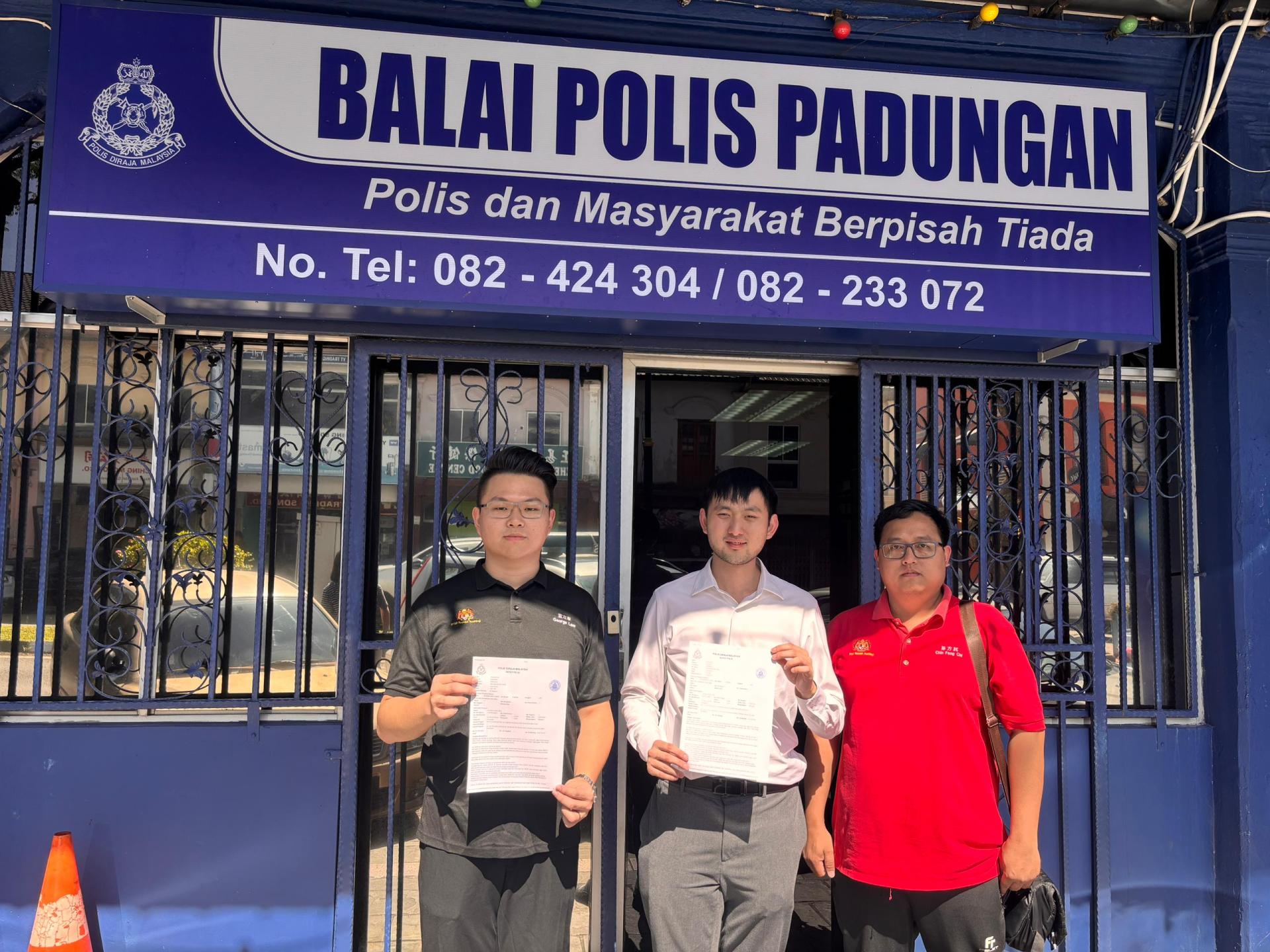 左起砂社青团秘书蓝立康、委员张翰贤和组织秘书陈方其在警署外展示报案书。