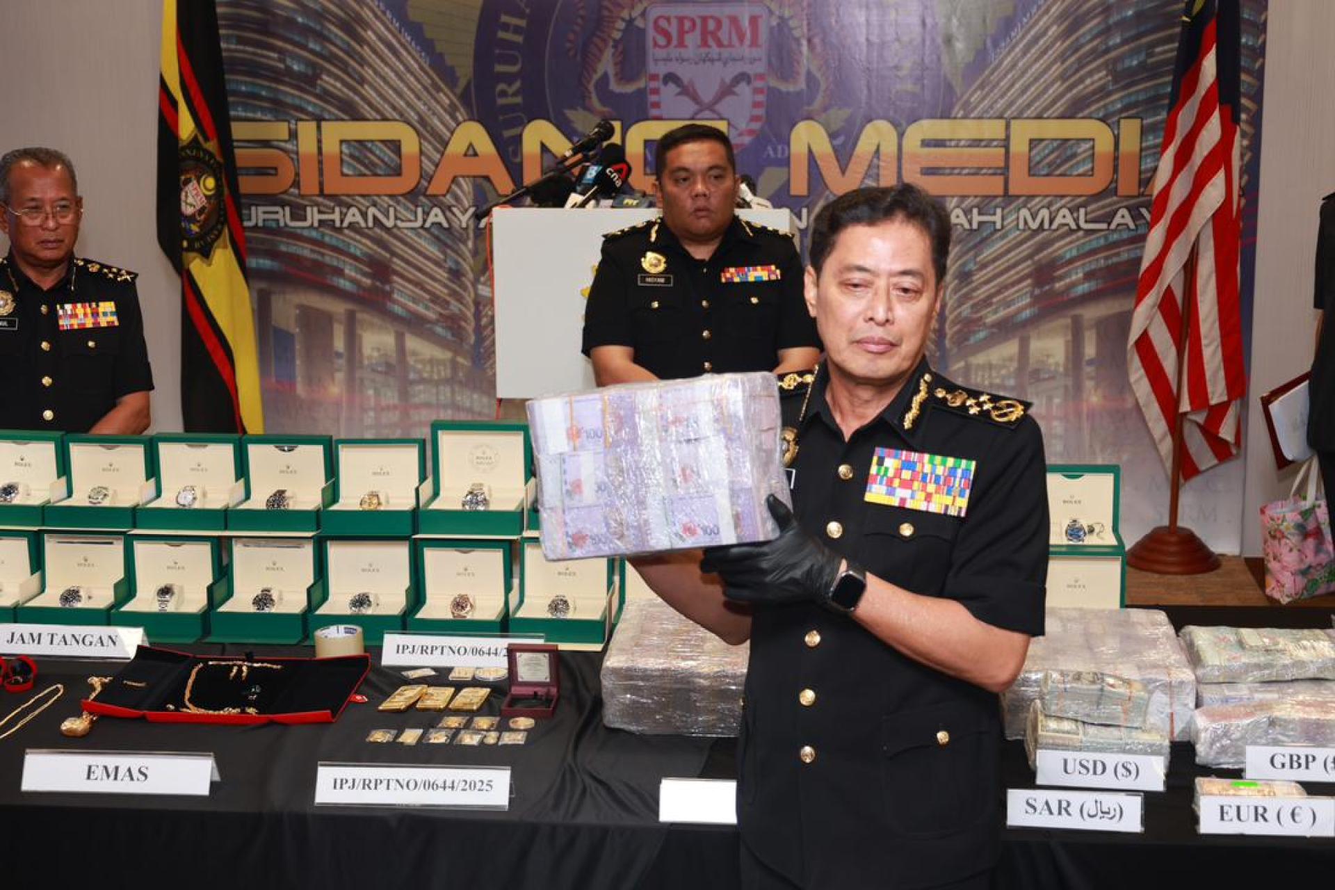 阿占巴基（左3）与反贪会官员展示该委会在Op Parasit中，冻结、扣押及充公了4390万令吉的部分财物。