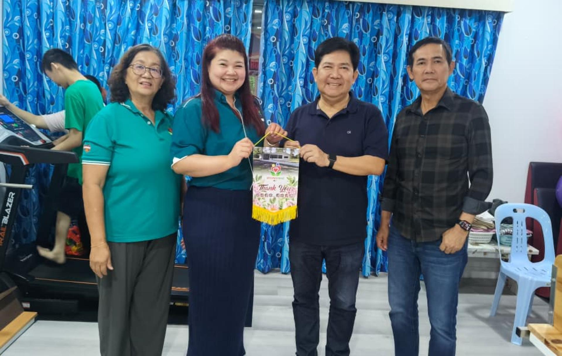 美里唯心乐园主席何消凌（左2）移交感谢锦旗予爱心筹款活动发起人关逸凡，左为美里唯心乐园秘书陈月燕。