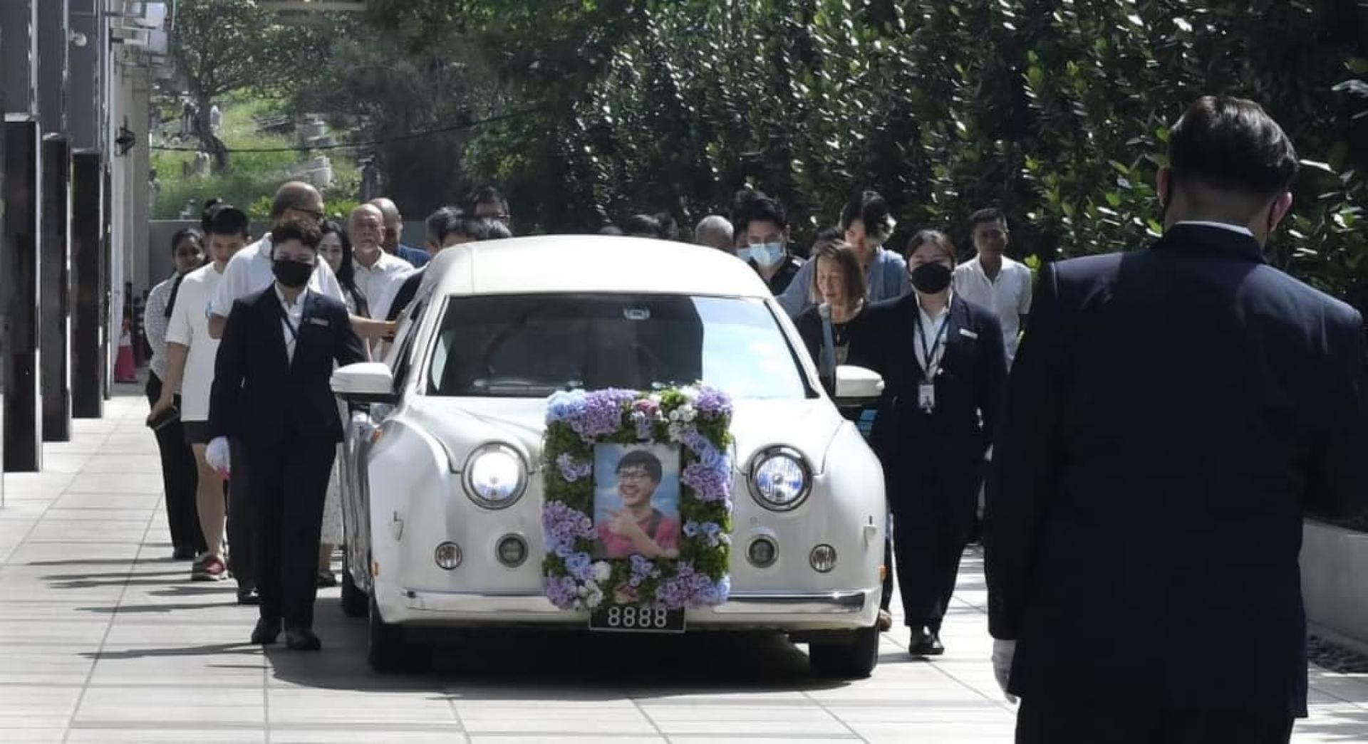 死者亲属与朋友随着灵柩车，缓缓离开殡仪馆。