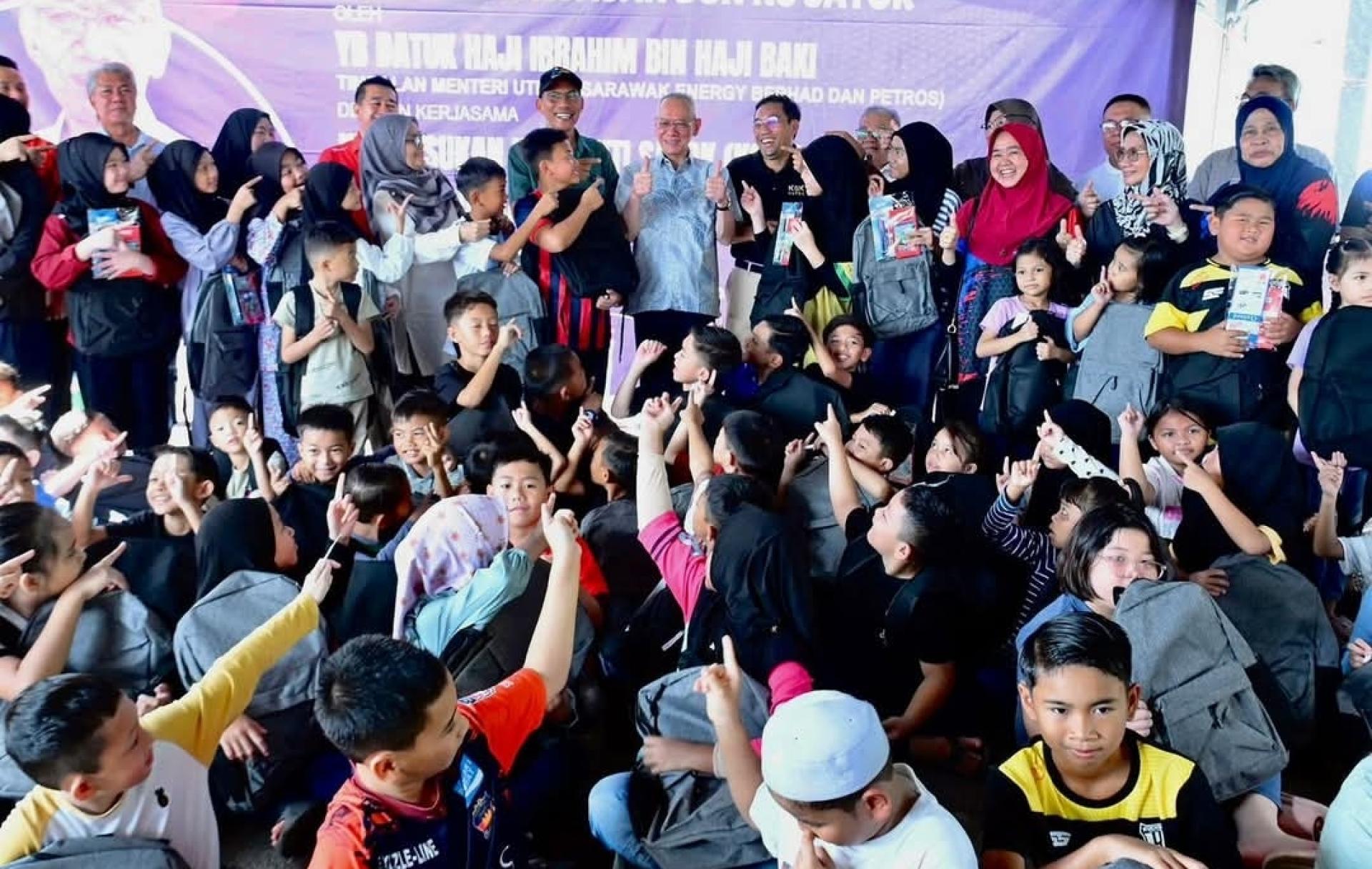 拿督伊布拉欣巴基（后方中）与当局代表及部分受惠孩子合影。