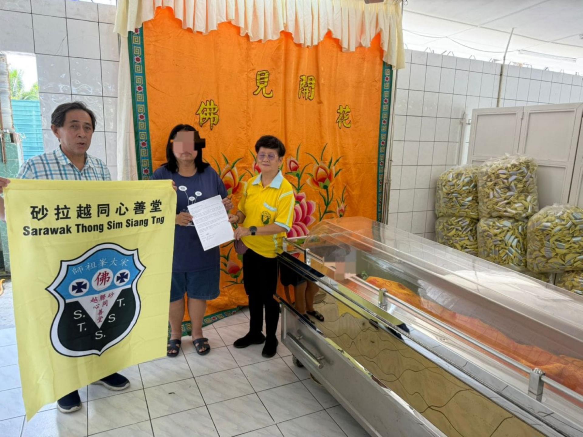 砂同心善堂副福利张淑禧（右）移交助葬经费予许女士办其母亲丧事。左为该善堂执行秘书陈惠生。