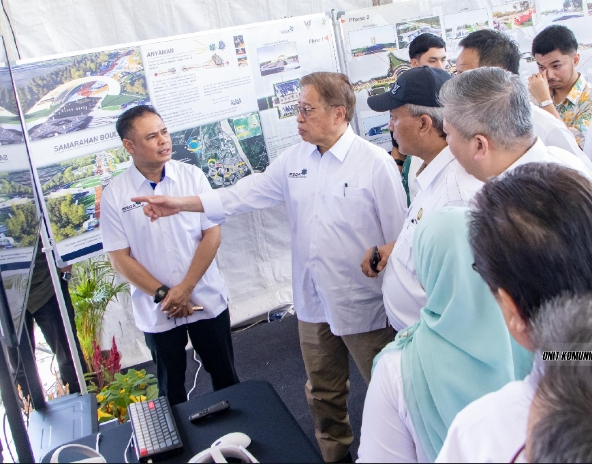 砂总理阿邦佐哈里（左2）透过图表了解发展情况。