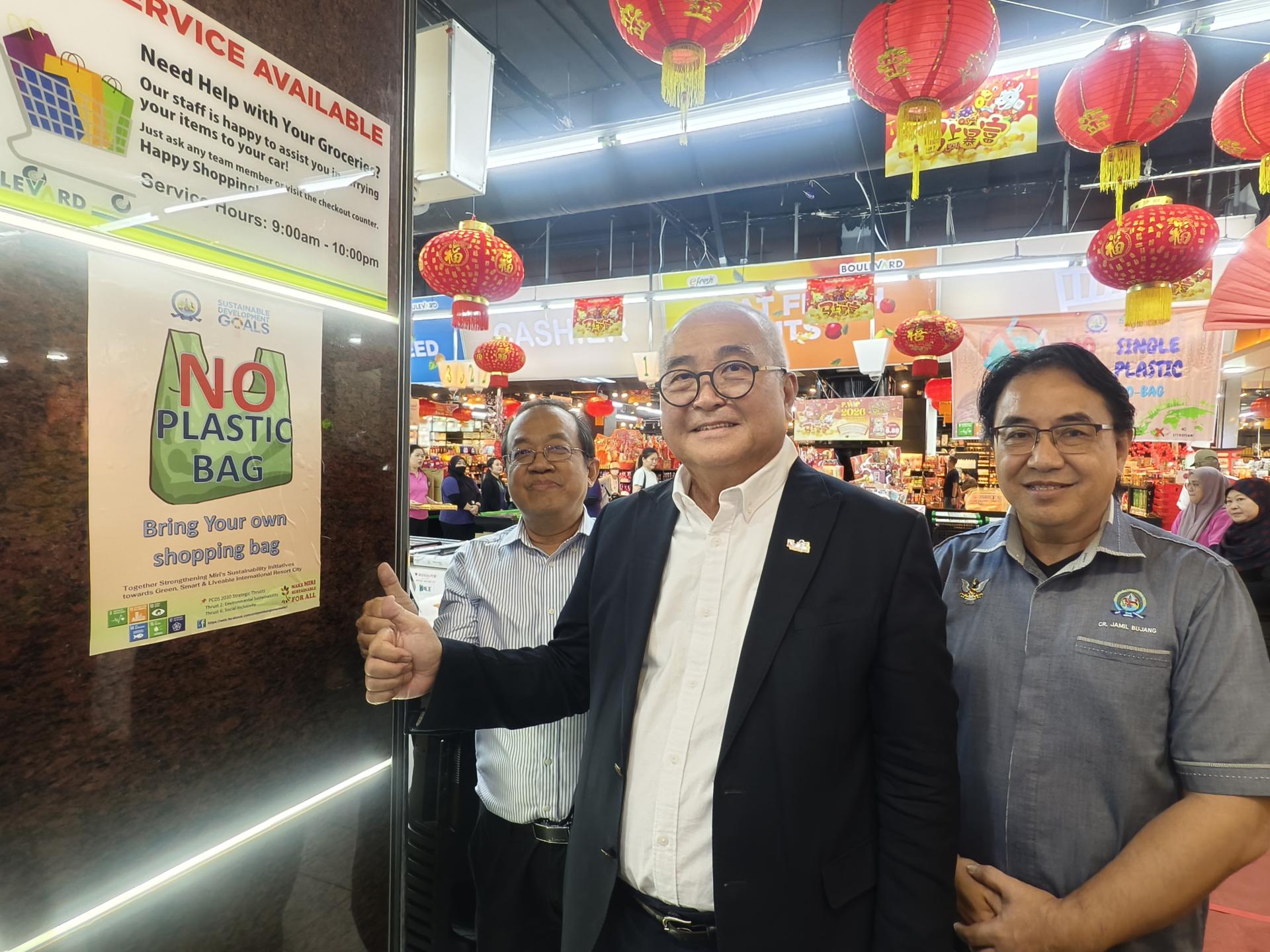 美里市政局旅游发展工作小组正式推行“无塑料袋运动“以全面减少 一次性塑料袋的使用，鼓励民众在购物时自备环保袋。左起为富丽华霸级百货有限公司首席运营员卓振发，美里市长俞小珊及美里市议员嘉米尔在霸市门口贴上海报合影。