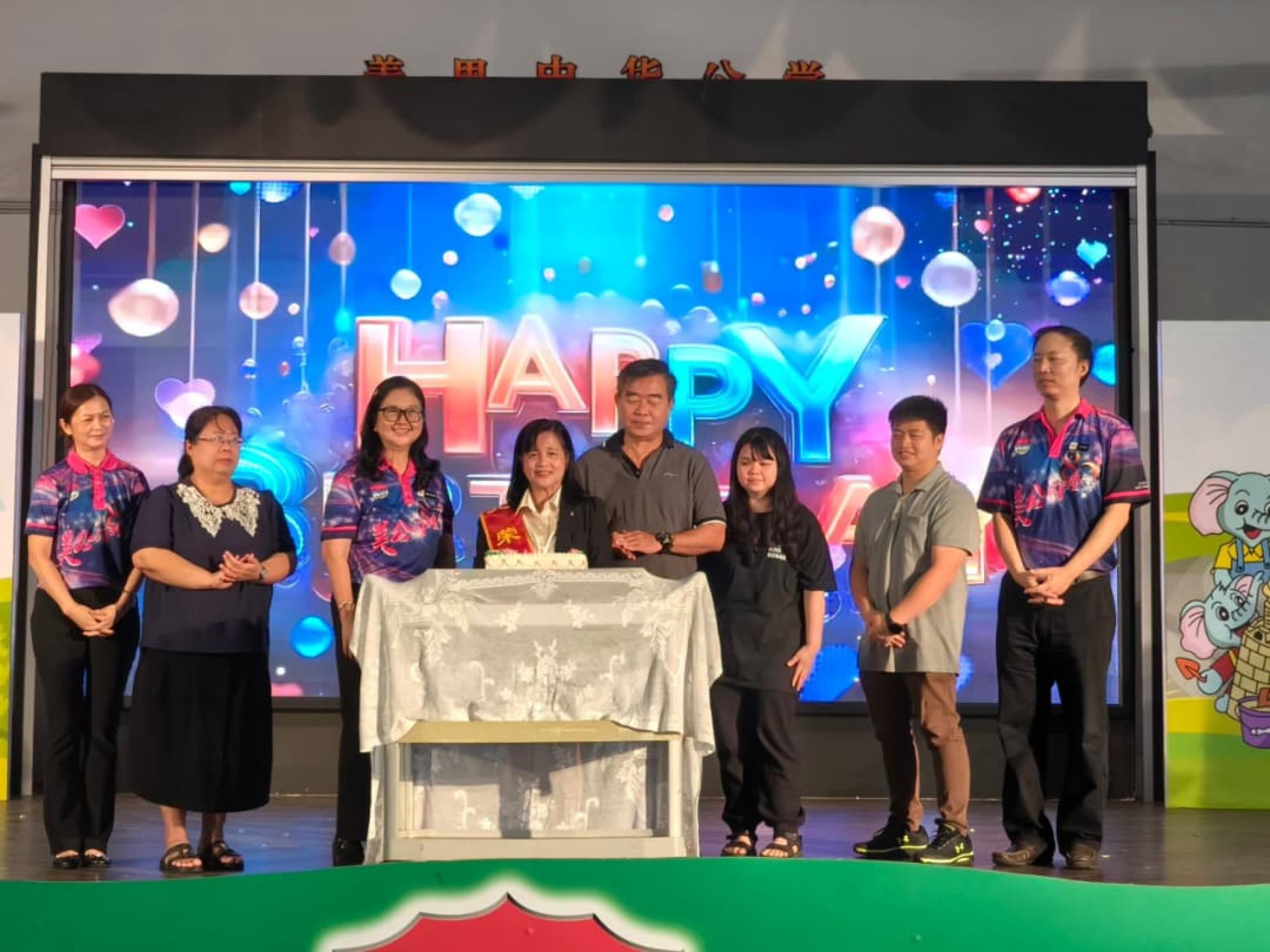 陈凤蓉老师（左4）在美公校长陈泳伽（左3）与家人的陪同下切生日蛋糕。