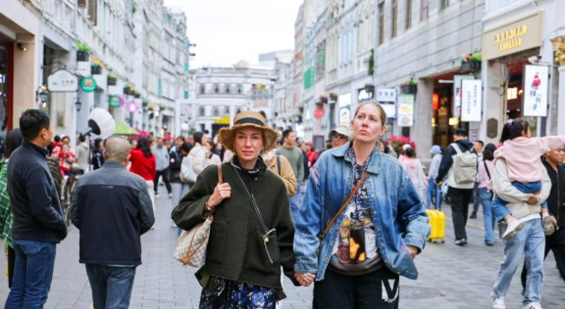 外国游客漫步海口百年骑楼老街。