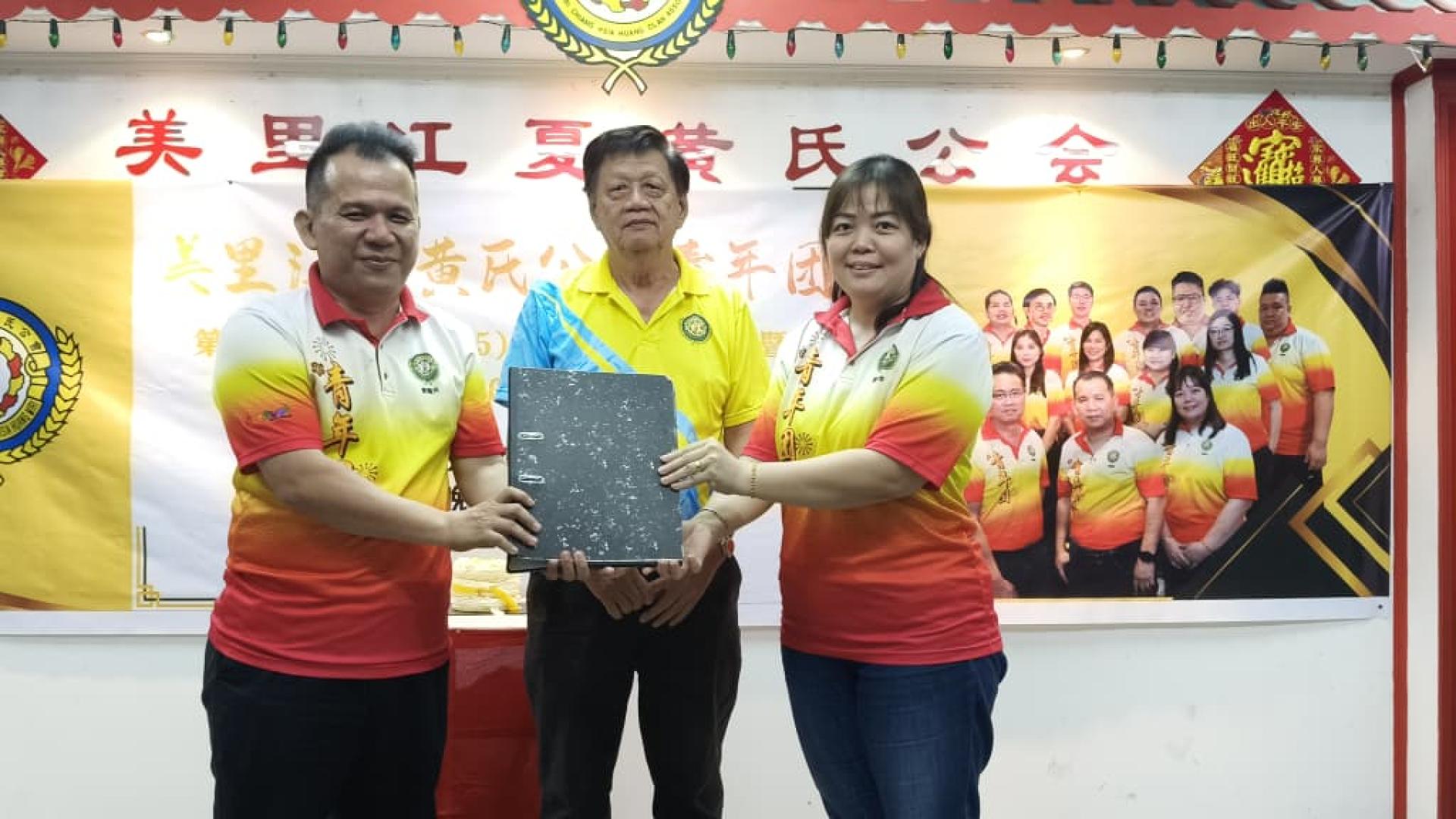 黄隆兴（左）在美里江夏黄氏公会（2026至2028年）新任会长黄能喜（中）见证下移交职权予第21届（2026至2028年）新任青年团团长黄秀华。