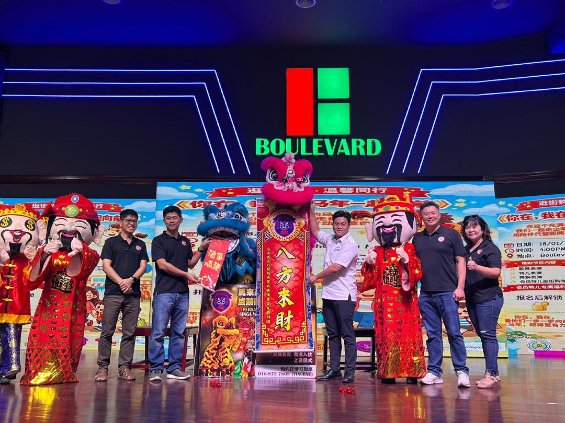 舞狮表演为活动增添新春喜庆气氛，左为中心副主席张家雄与邹梓建（右）从舞狮口中接过贺联。